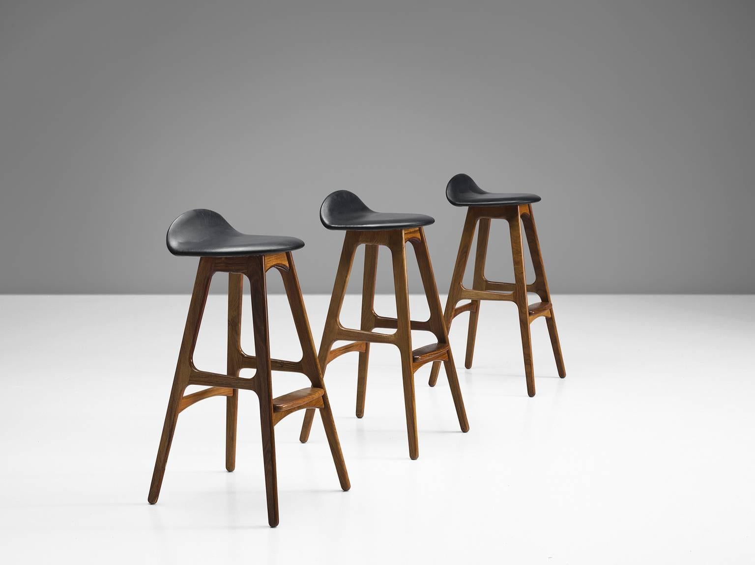 Erik Buch for O.D. Mobler, bar stools, rosewood and black faux leather, Denmark, circa 1960s.

Distinctive set of three barstools by Erik Buck (1923-1982). Buch had over 30 commercially successful production designs over his career but none so