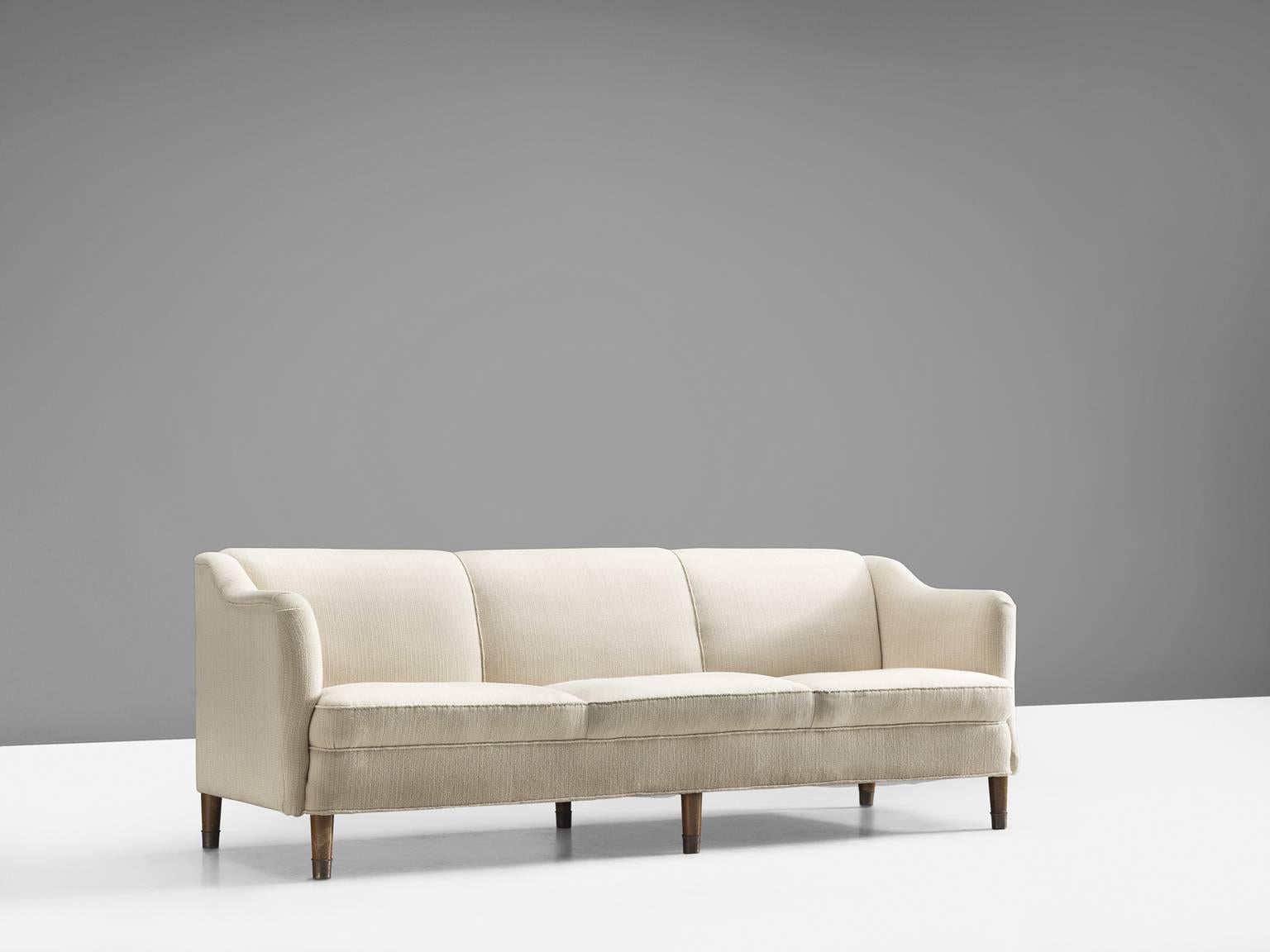 Three-seat sofa, in walnut and white fabric, Denmark, 1950s. 

This sofa shows exquisite Danish craftsmanship and aesthetics. The settee features a soft, curving back and comfortable cushions in both the seat and back, as can be expected from