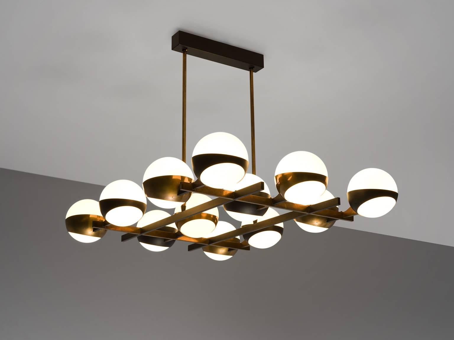 Stilnovo, brass, opaque glass, Italy, circa 1959

This chandelier by Stilnovo features twelve opaque glass globes. They are held in place by brass rings that are attached to a brass grid. The grid is attached to the base via two thin brass poles.