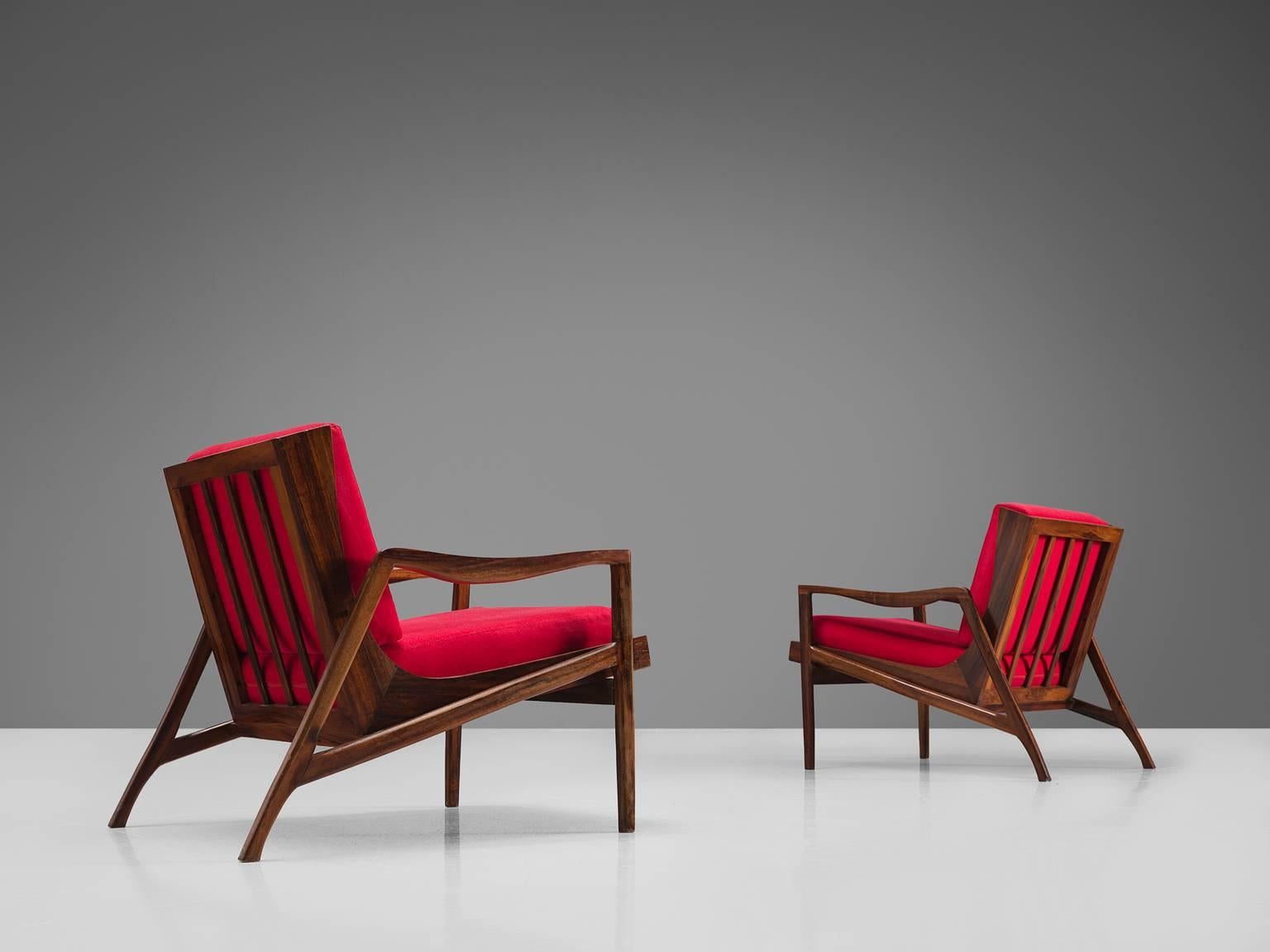 Liceu de Artes e Oficios, lounge chairs in red fabric and rosewood, Sao Paulo, Brazil, 1960s.

These sculptural Brazilian lounge chairs are made of solid dark stained wooden construction and feature a slatted back. The frame is delicate and robust