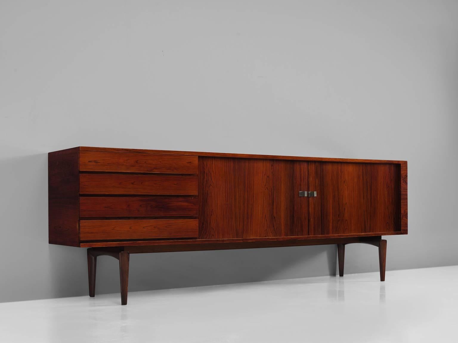 H.W. Klein, sideboard, in rosewood and metal, Italy, 1950s. 

This large Italian sideboard is designed by H.W. Klein. The credenza shows exquisite craftsmanship and balanced proportions and strong details such as the geometric unsymmetrical brass