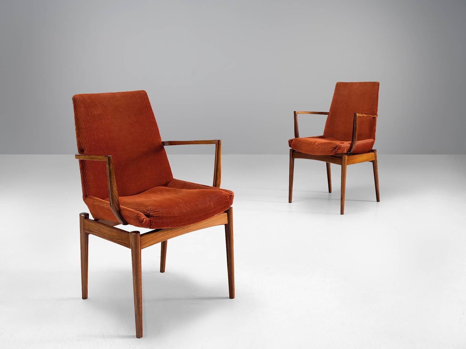Set of two side chairs, rosewood, red orange corduroy, Scandinavia, circa 1955.

The set of two chairs is sensuous, sculptural and elegant. The chairs feature high backs, and dramatically high and sculpted armrests. The curved, tapered legs are