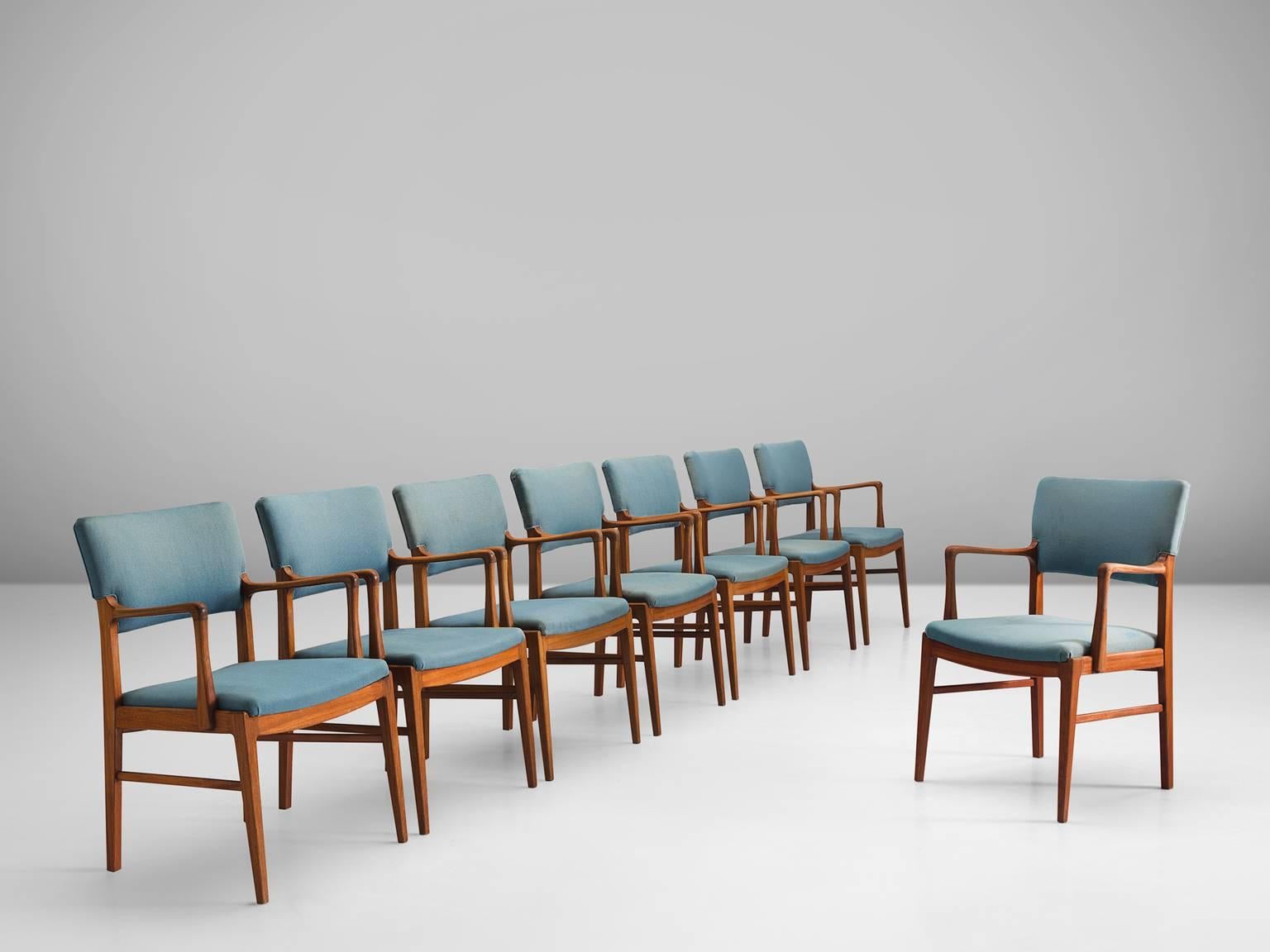 Set of eight armchairs, teak and turquoise fabric, Scandinavia, 1950s. 

These elegant teak dining chairs with armrests are both stately and modest. These Scandinavian chairs have a teak frame with a beautiful visible grain. Nicely curved armrests