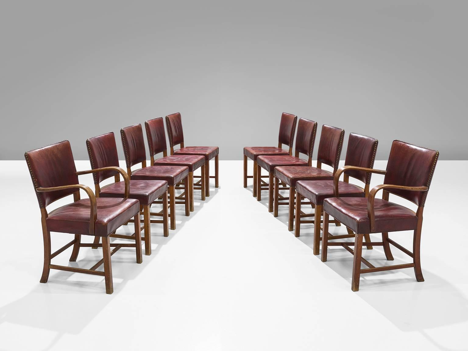 Fritz Hansen, dining chairs, eight without arm, two with arm, beech and red leather, Denmark, 1940s.

These chairs are strong and sturdy. They seem almost proud about their appearance. These chairs once served on board of the ship Aegir. The