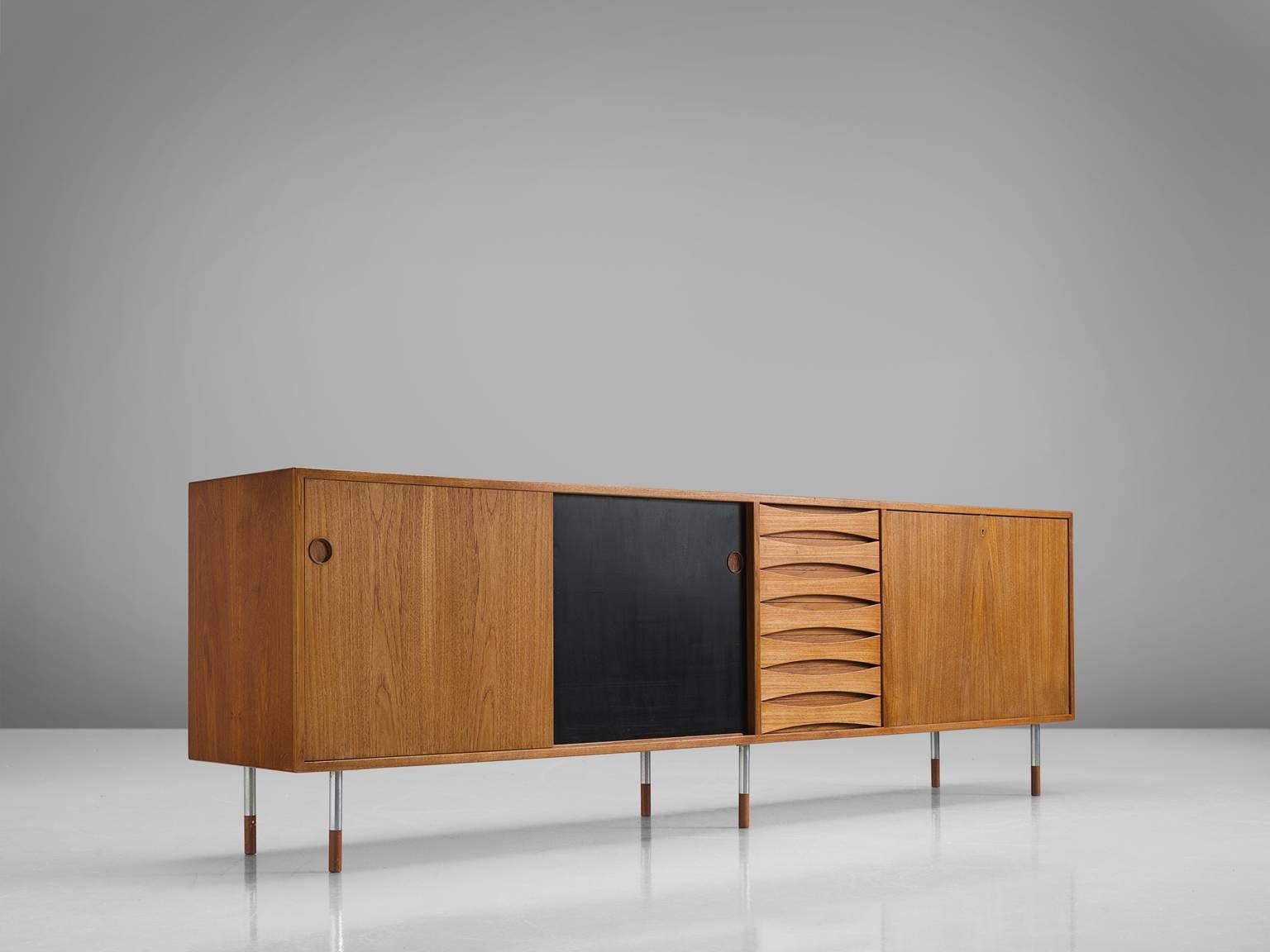 Arne Vodder for P. Olsen Sibast Møbler, Credenza model 29A, in teak and metal, by Denmark, 1959.

This iconic sideboard in teak is designed by the Danish designer Arne Vodder. The typical refined Vodder details can be found on this sideboard such as