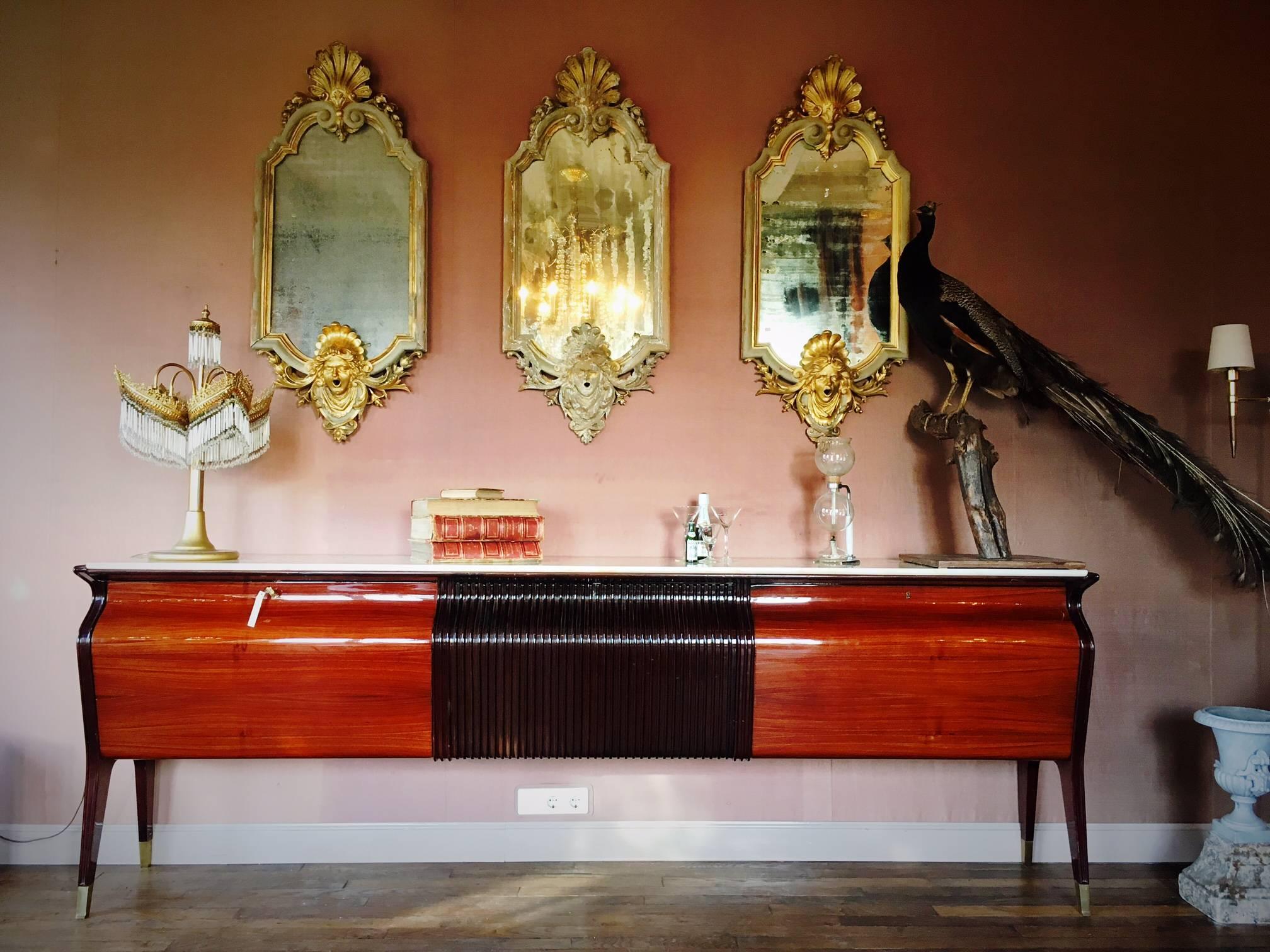 Cabinet in the style of Italian designer Osvaldo Borsani (1911-1985). Borsani studied art and architecture in Milan. He became very well-known as a designer of furniture with technical innovations. The prunus surface is very shiny and in a great