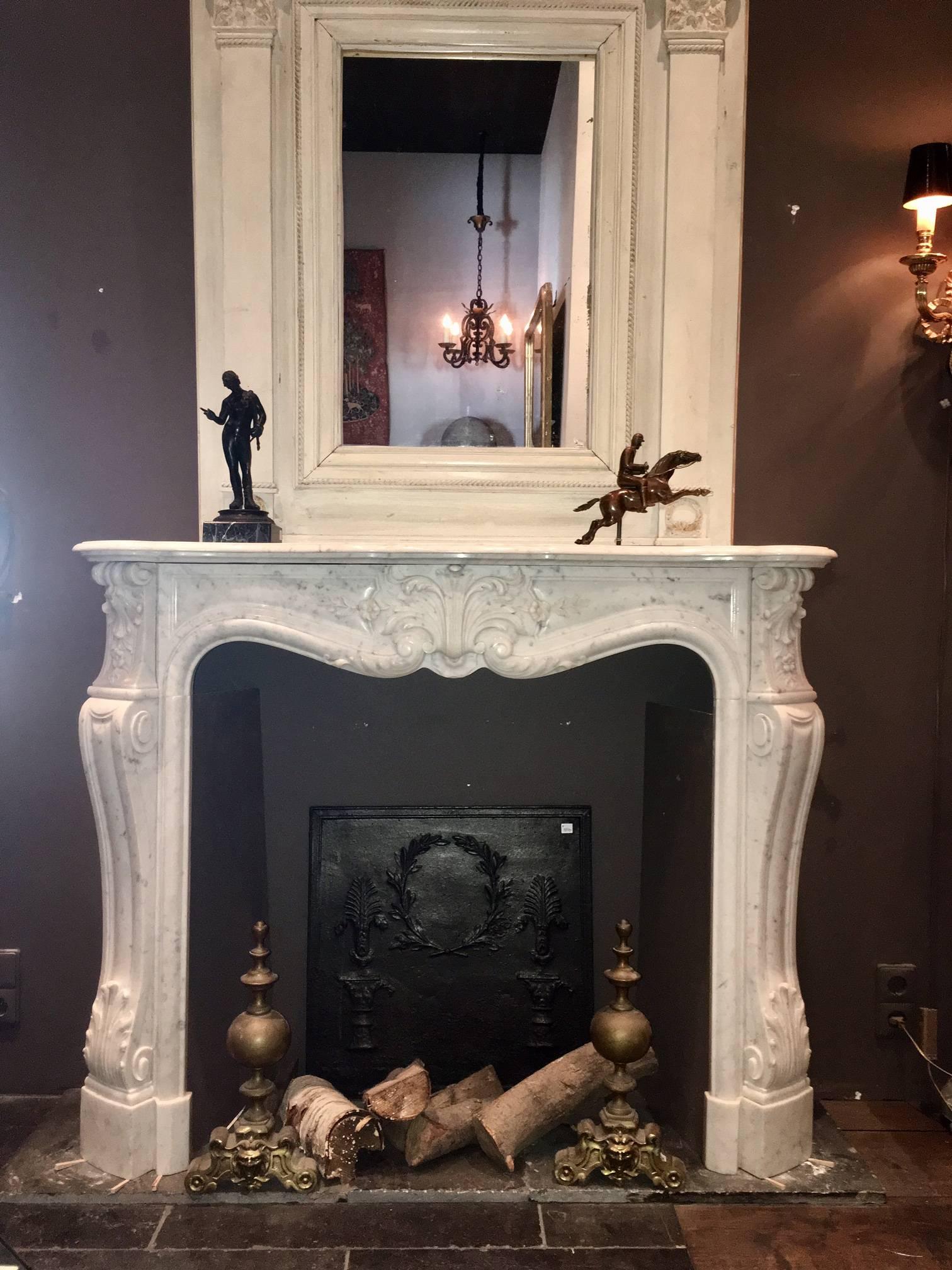 Beautifully carved French fireplace in the style of Louis XV. This type of fireplace was very much in fashion in Paris in the mid-19th century. The fireplace is richly decorated with floral shapes. The fireplace is made from fine Italian Carrara