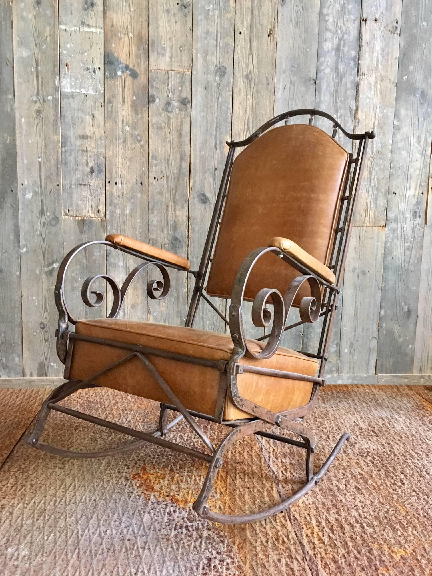 Beautiful French mid-19th century rocking chair. The chair is made from wrought iron and leather, very heavy but also very comfortable. 

The leather back is attached to the iron frame with tension springs. The leather has a beautiful worn look.