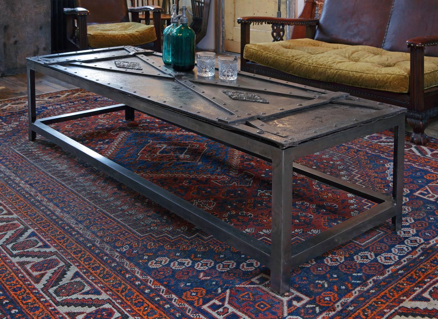 A coffee or center table made of a 17th century Italian wrought, cast and riveted iron door 