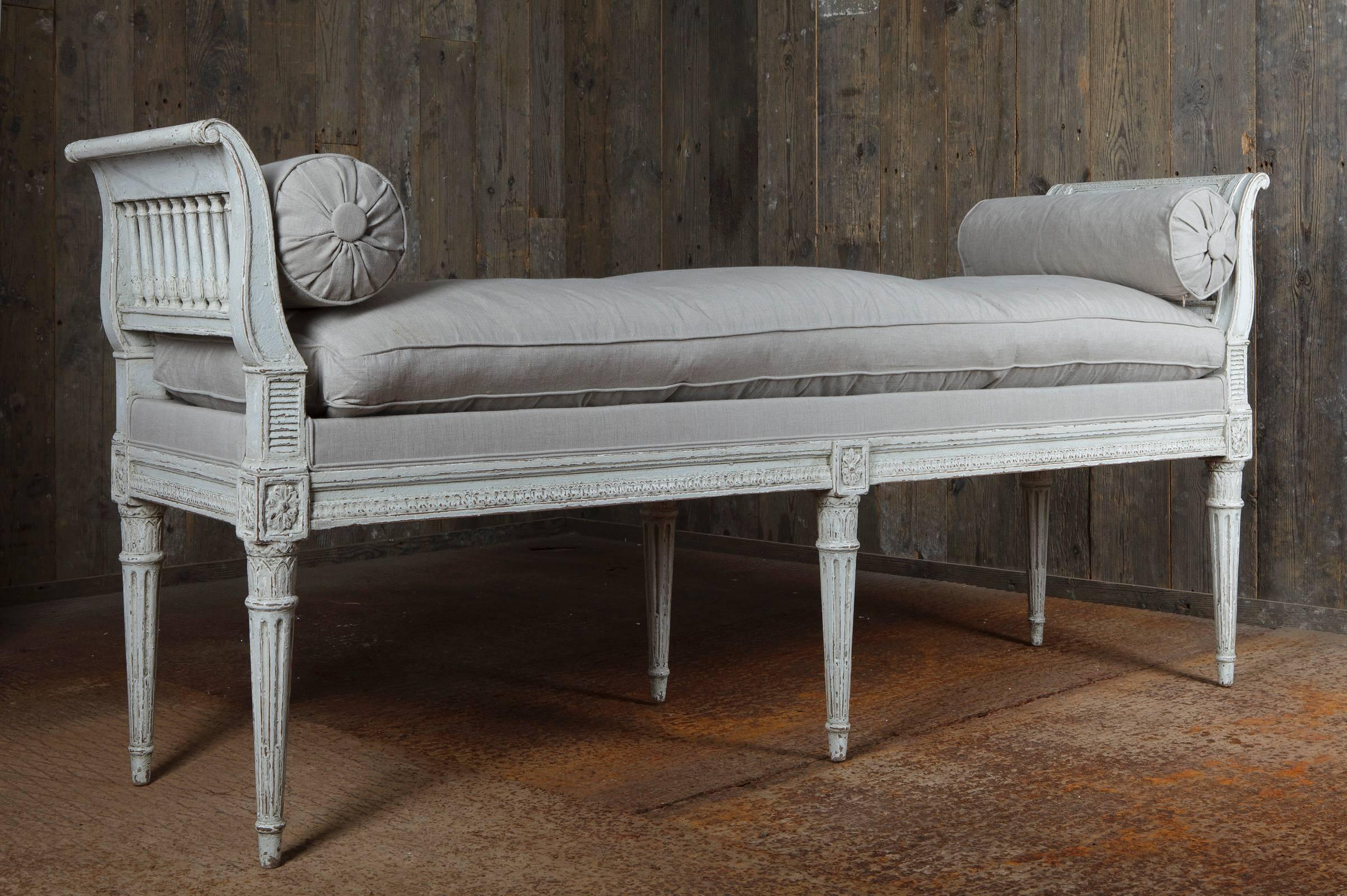 With tapering, fluted legs, richly carved with rosettes, the armrests with a fine row of columns, recently with linen upholstered.
