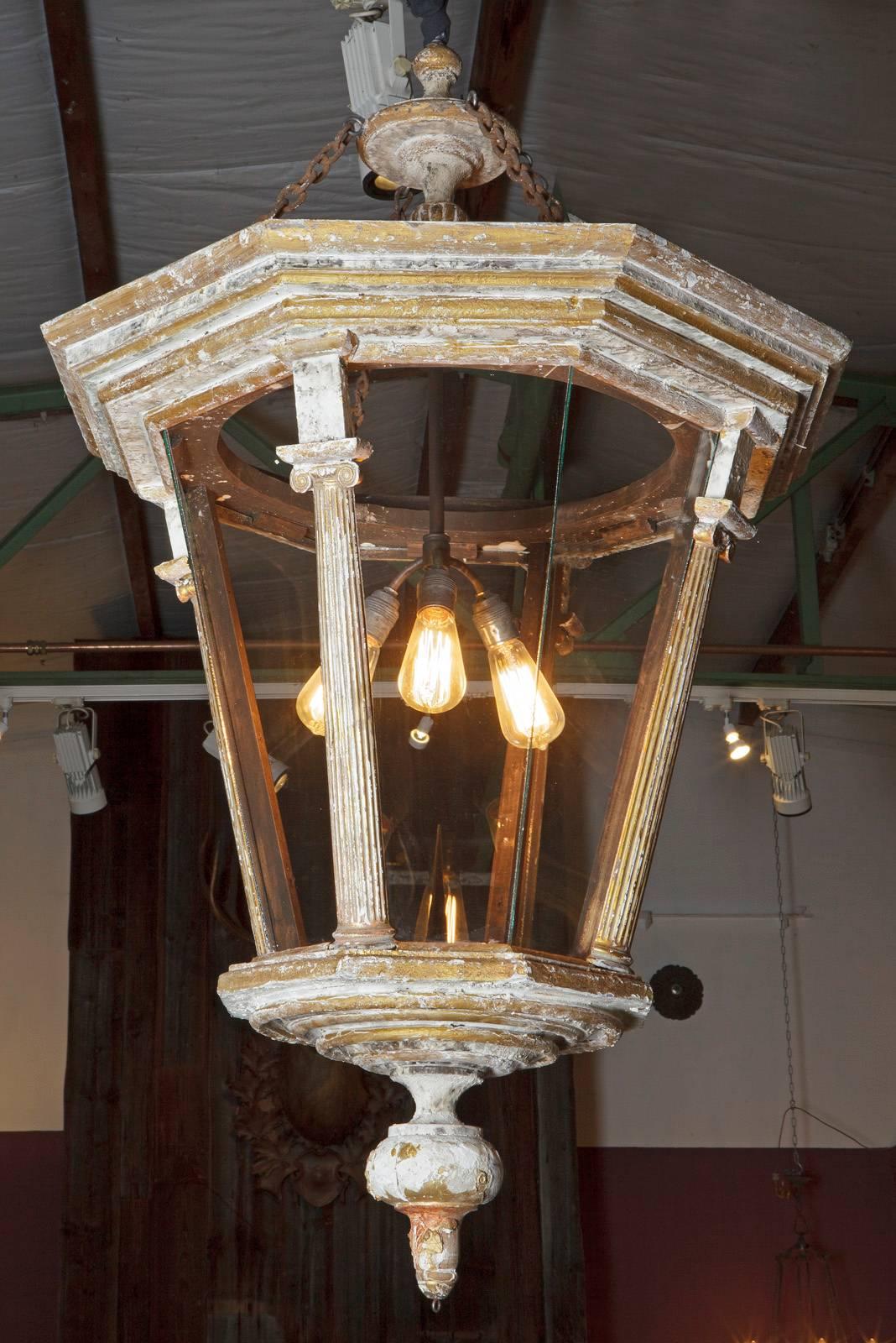 Beautiful large lantern compiled of antique wooden elements.
The glass plates are separated by beautifully carved ionic pilasters.

The lantern is 128 cm in height ex. the wire.
