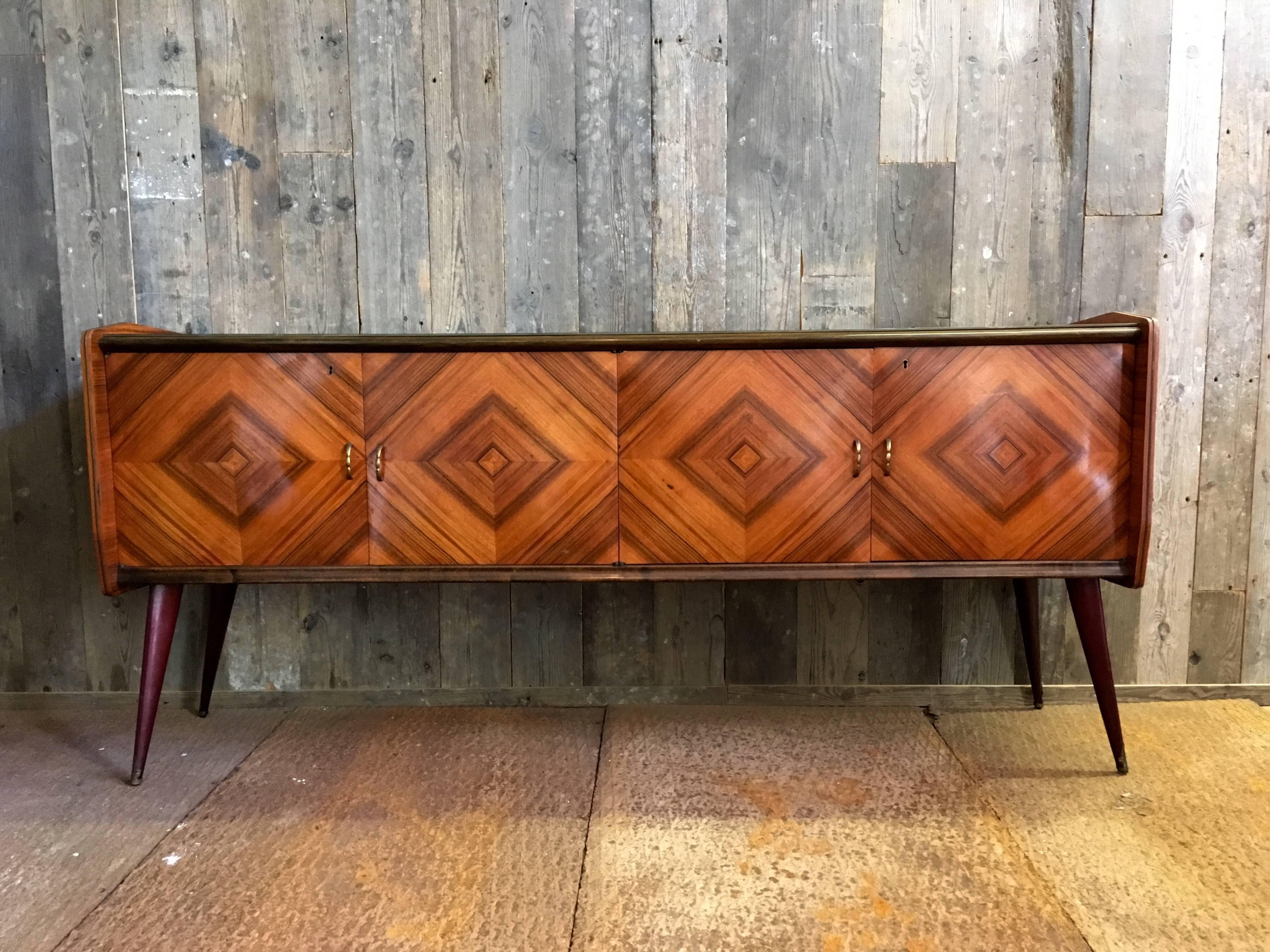 Rare rosewood veneered design sideboard by Vittorio Dassi (Milan, 1893-1973).

The rosewood veneer creates a beautiful rhombus pattern on the four doors. The handles are made of brass and a glass plate covers the top of the sideboard.
