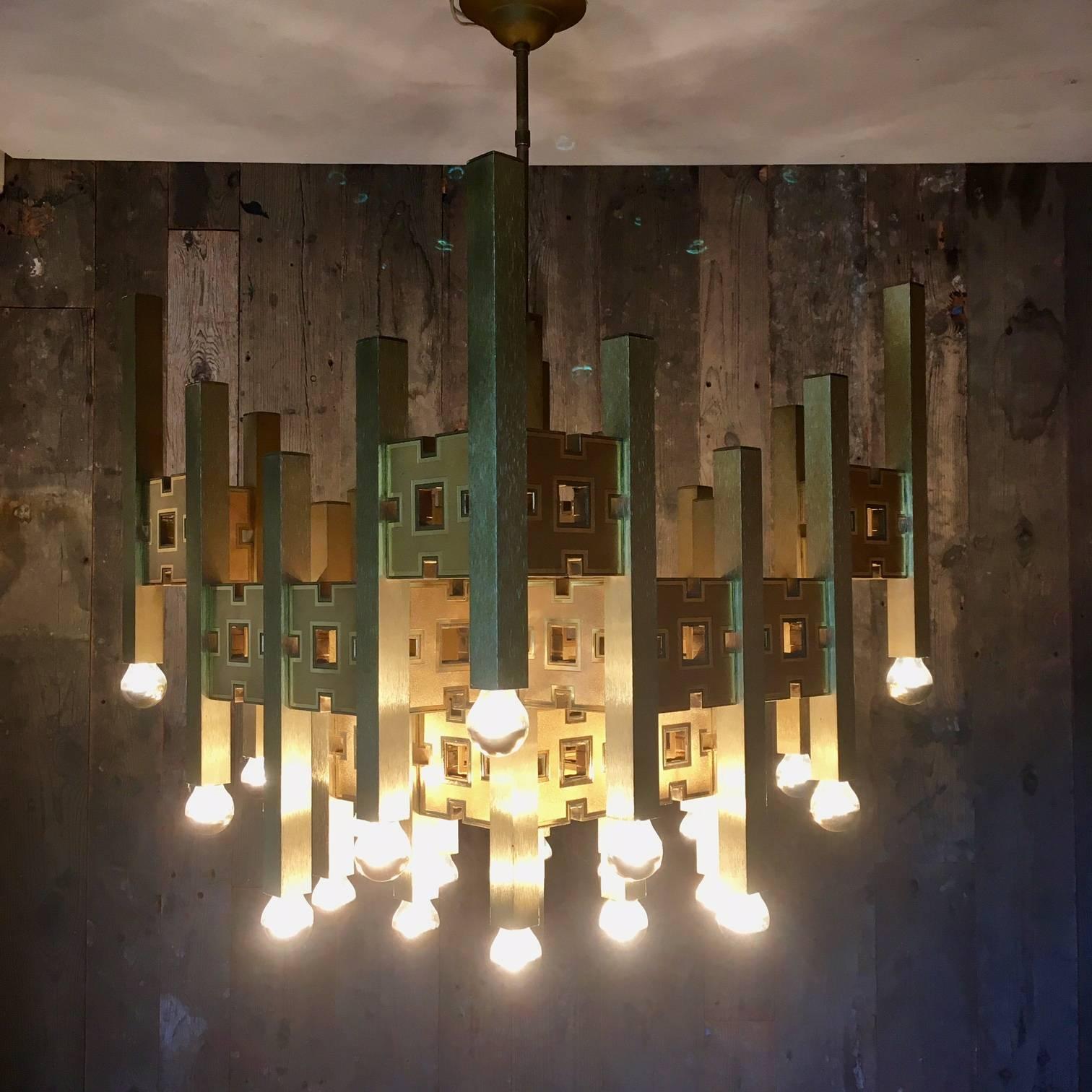 Spectacular brass modernist twenty-four lights chandelier by Gaetano Sciolari.
Made out of brass cubes and rectangular shapes. Measures: Square shaped 59 x 59 cm. Height excluding bar 65 cm. 

Angelo Gaetano Sciolari (1927-1994) was a movie