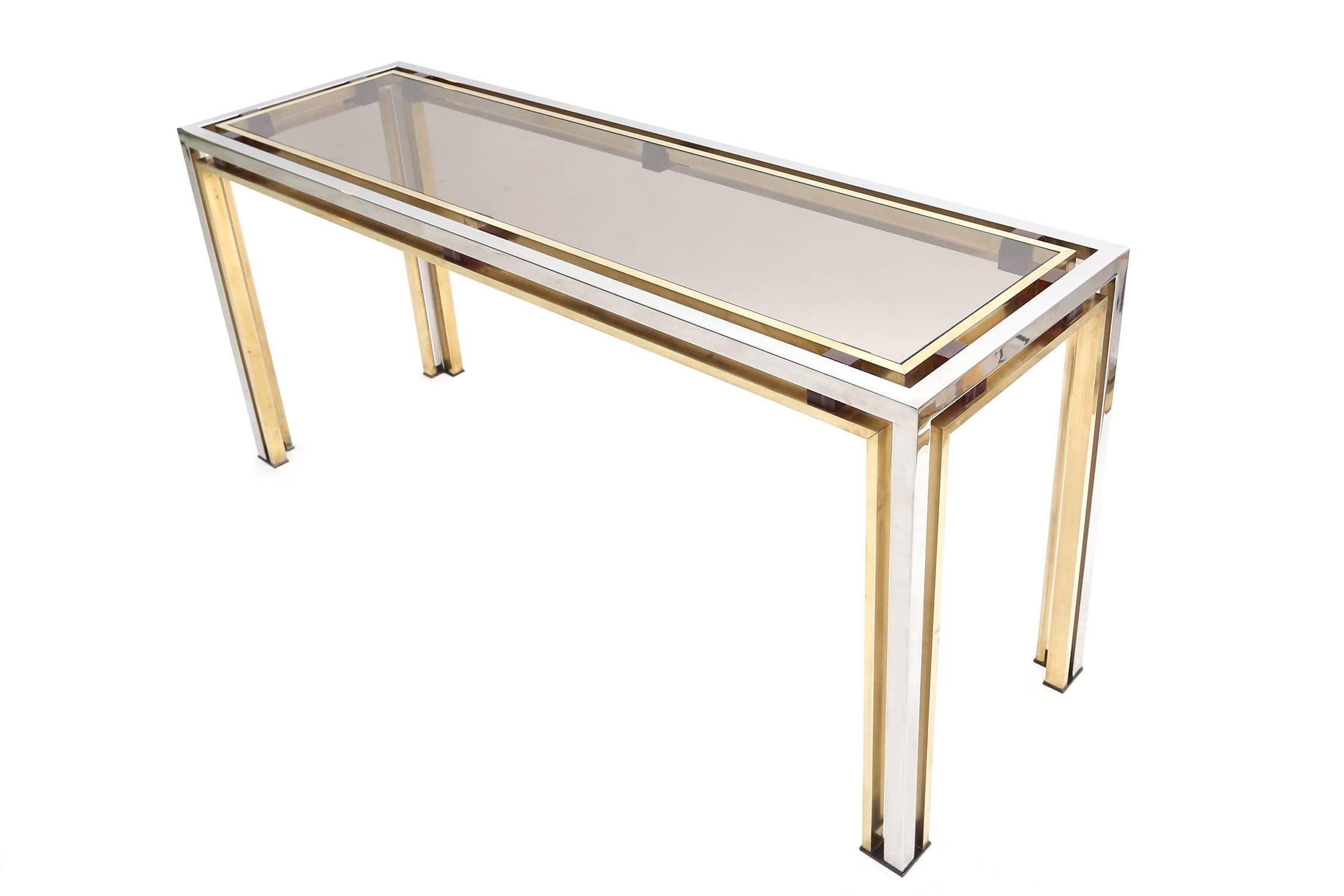 A superb console table by Romeo Rega, signed at the base.
Double-framed floating glass top is encased in a brass and chrome double frame.
Two toned structure, purple Lucite accents, continuous on the legs.
Italy, circa 1977.
Measures: W 160 cm H