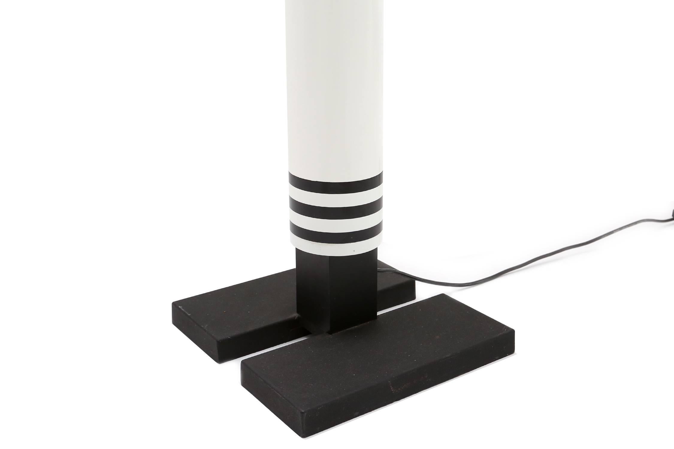 A Classic Memphis floor lamp
by Mario Botta for Artemide, Italy, 1986.
The shogun floor lamp is no longer in production
cast iron base and white and black center stem with curved steel mesh shades at the top.
Measures: H 216 cm.