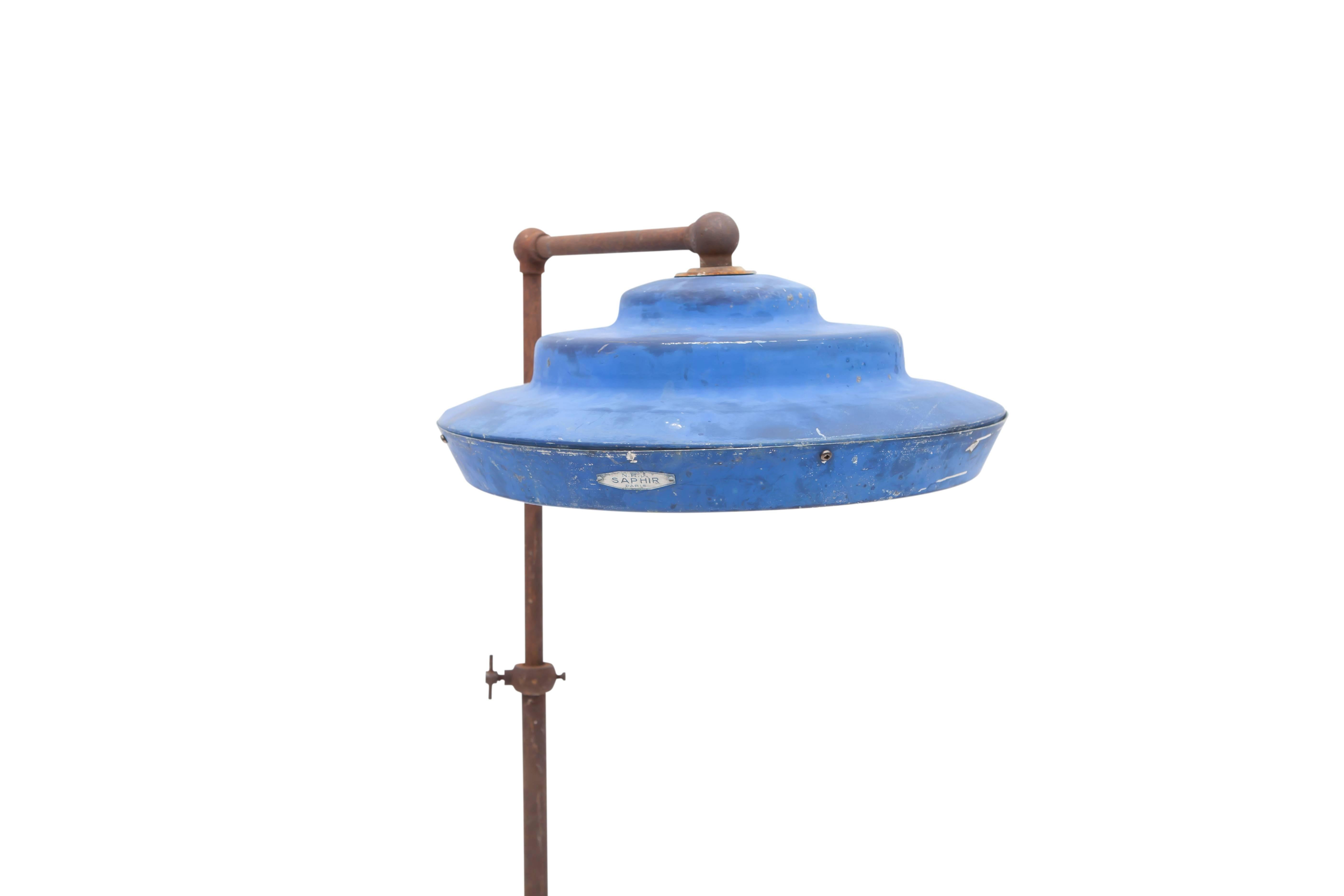 Industrial floor lamp Saphir Paris with original blue shade.
Mounted on Tripod iron base.
An Early 20th century 'machine age' piece in original condition.
Great patina
Measure: H 142 cm x D 53 cm x W 43 cm 
