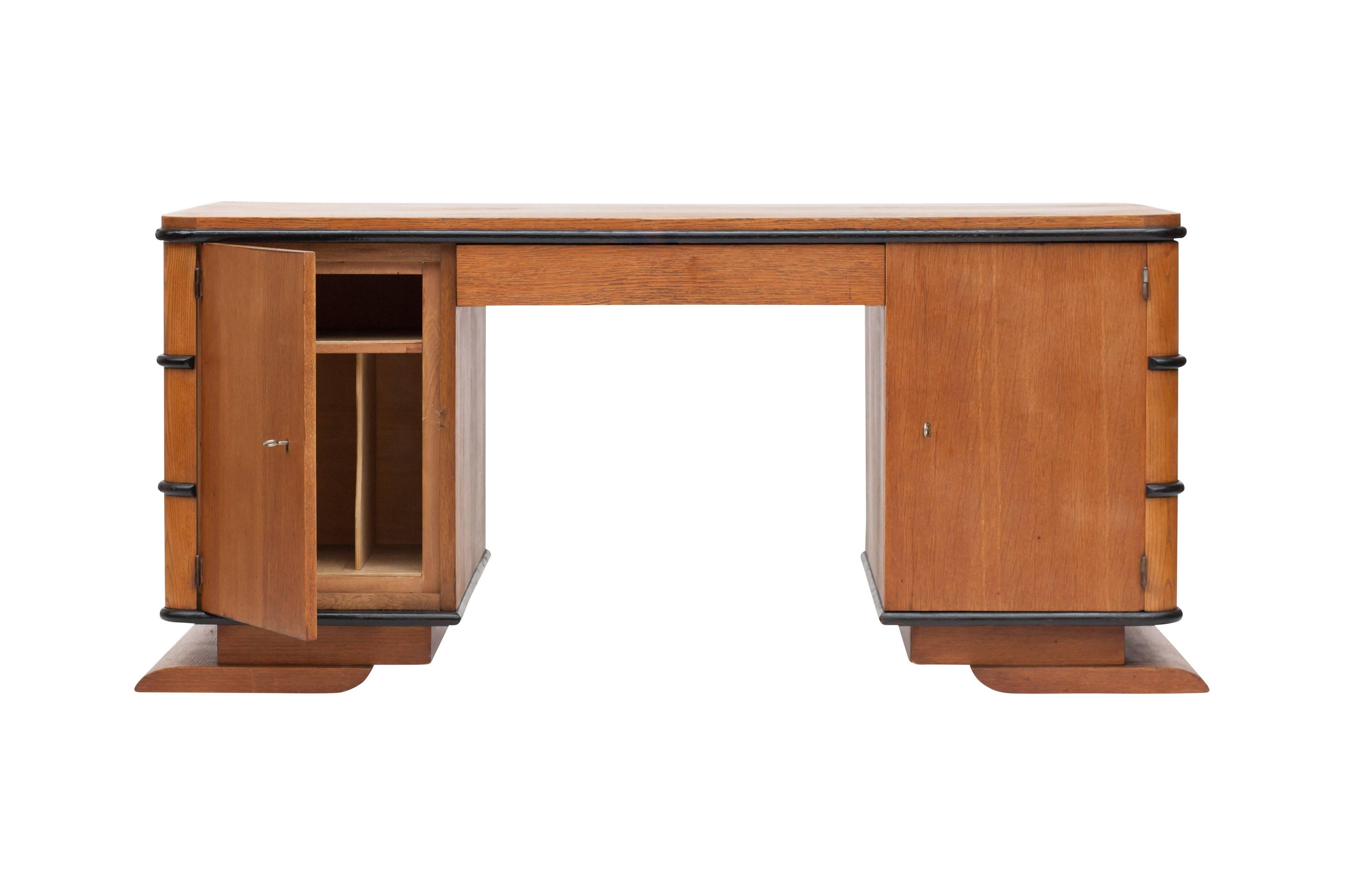 Wonderful streamlined Art Deco writing desk in Oak.

France, 1930s

Horizontal lining referring to streamline modern Art Deco architecture that emphasised curving forms and long horizontal lines. Equipped with multiple drawers and storage