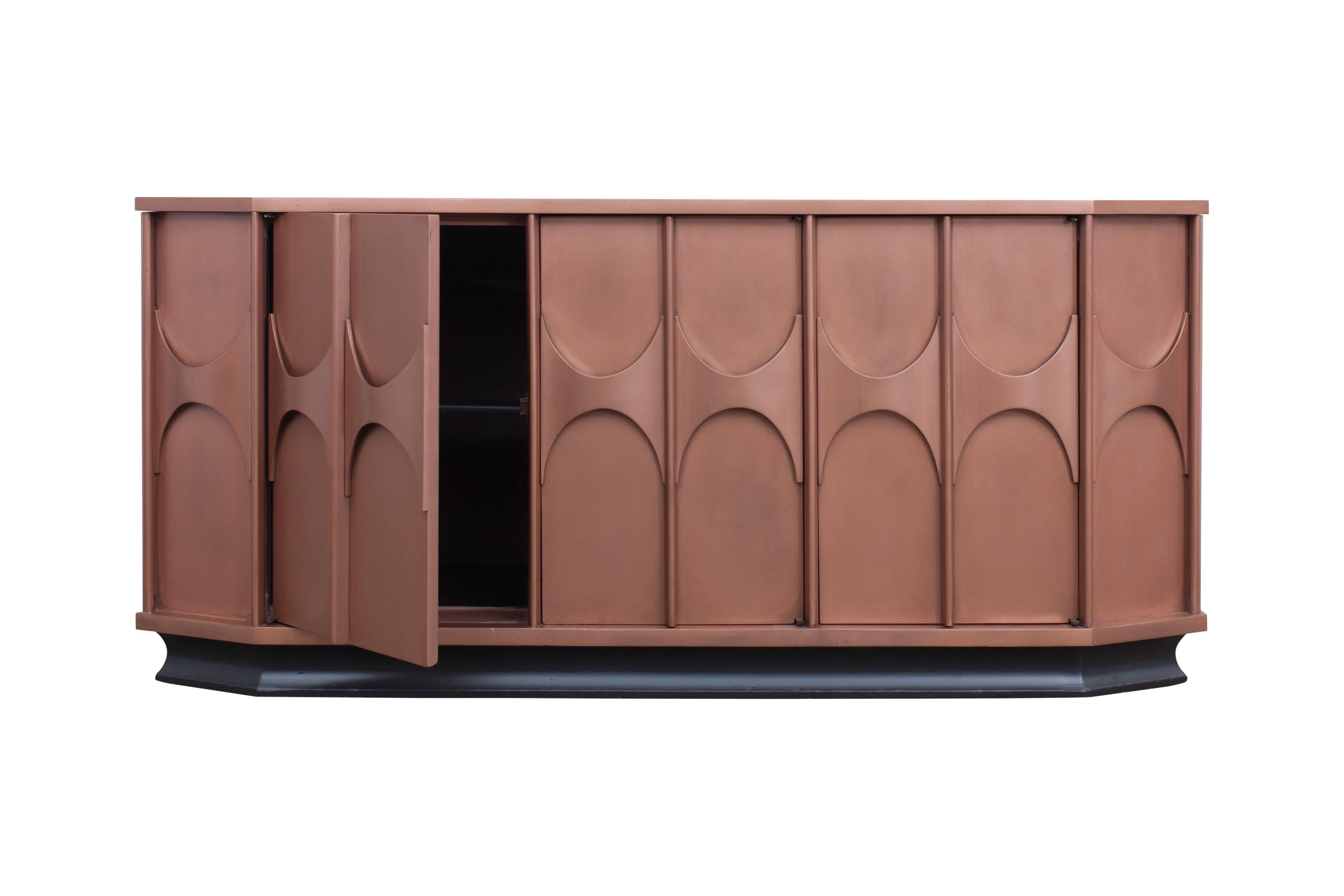Elegant Brutalist sideboard with well-crafted arches that function as door handles.

The item is provided with three doors, the middle door is equipped with three drawers.
Because of the black lacquered base, the cabinet gets a near floating