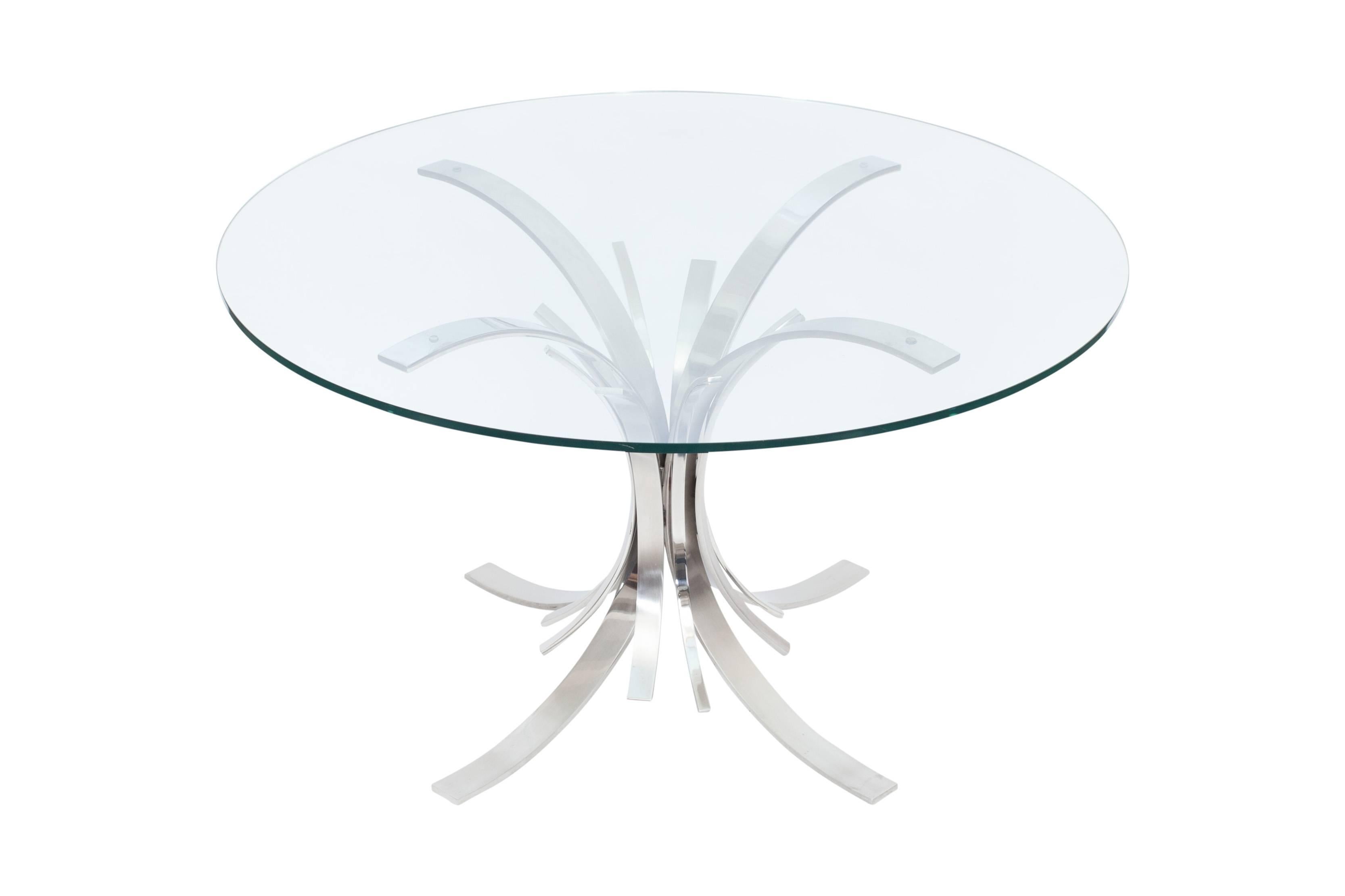 Stainless steel dining table with round glass top
by famous French female designer Maria Pergay.

Model 'Gerbe' 

France, 1975

Measures: Ø 130 cm, H 74 cm. 

Maria Pergay: Complete works 1957-2010.