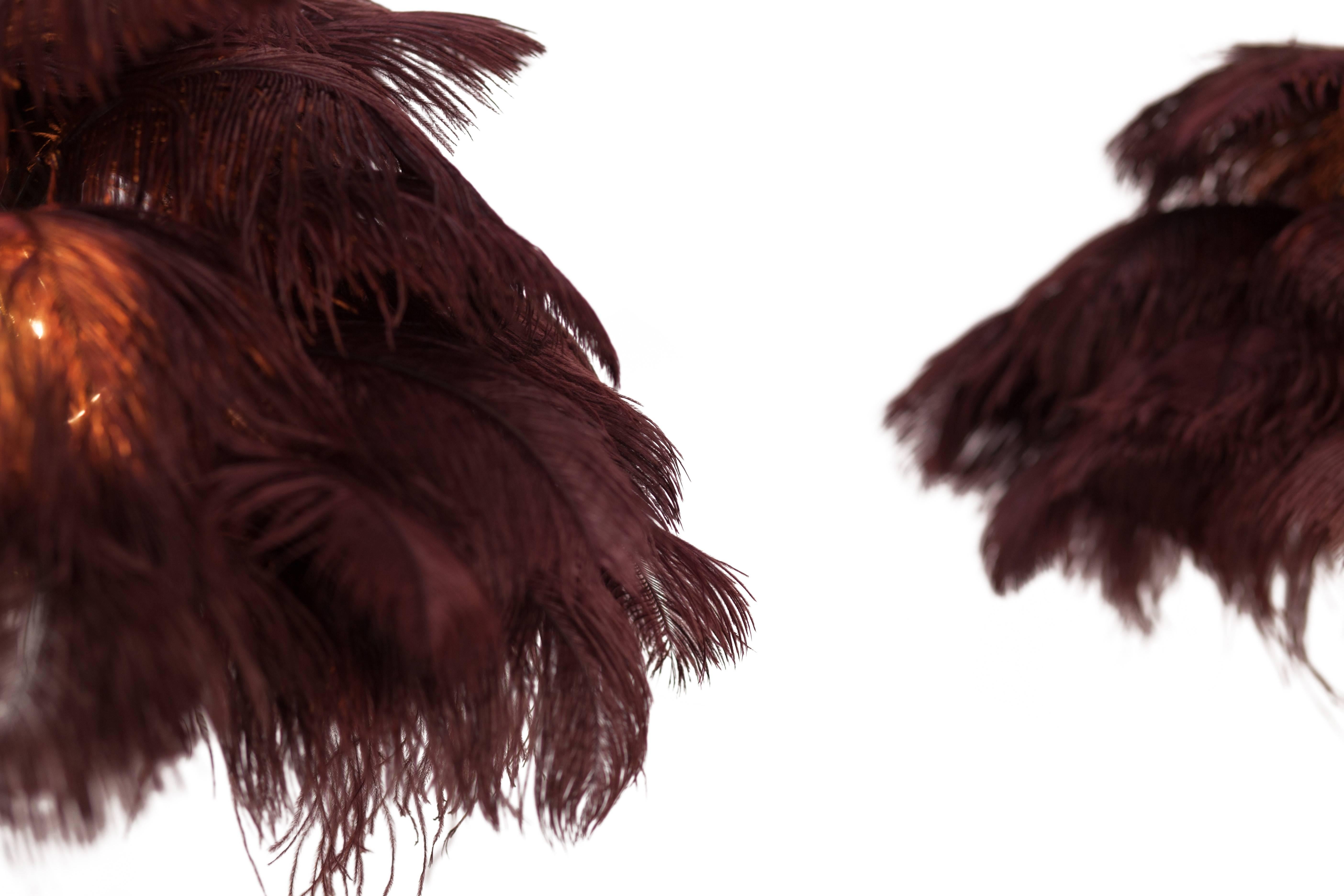 Small palm tree feather floor or table lamp.

Available as a single or as a pair

Hollywood Regency in the manner of Duval Brasseur 
Gold finished base with aubergine coloured ostrich feathers

highly decorative piece.

Measures: H 85 cm ø