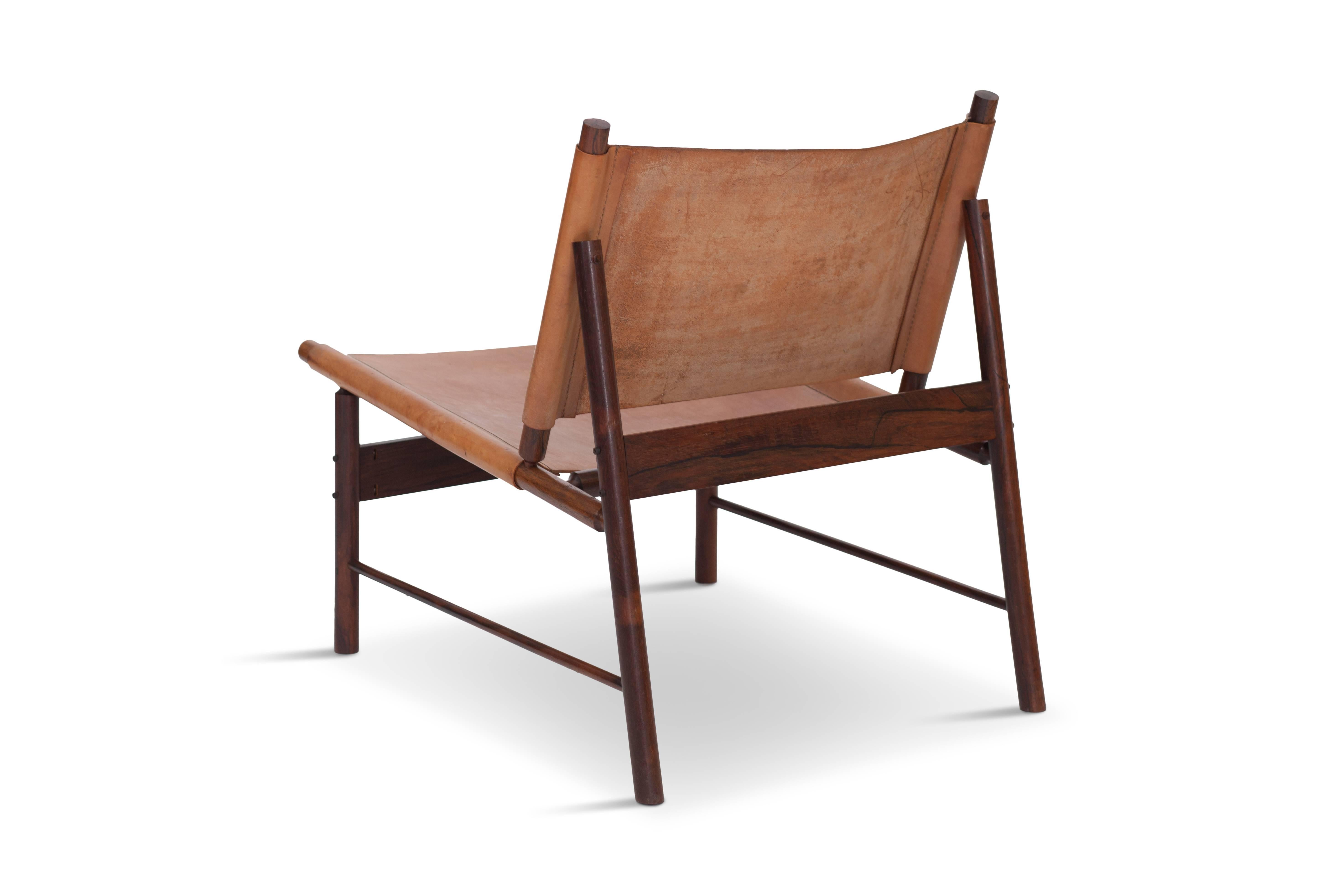 Elegant lounge chair in solid Brazilian rosewood and beautifully patinated cognac leather,
which is in great condition. Produced by L’Atelier, Brazil, circa 1955.
The chair has a very modernistic appearance due it’s sharp lines and subtle