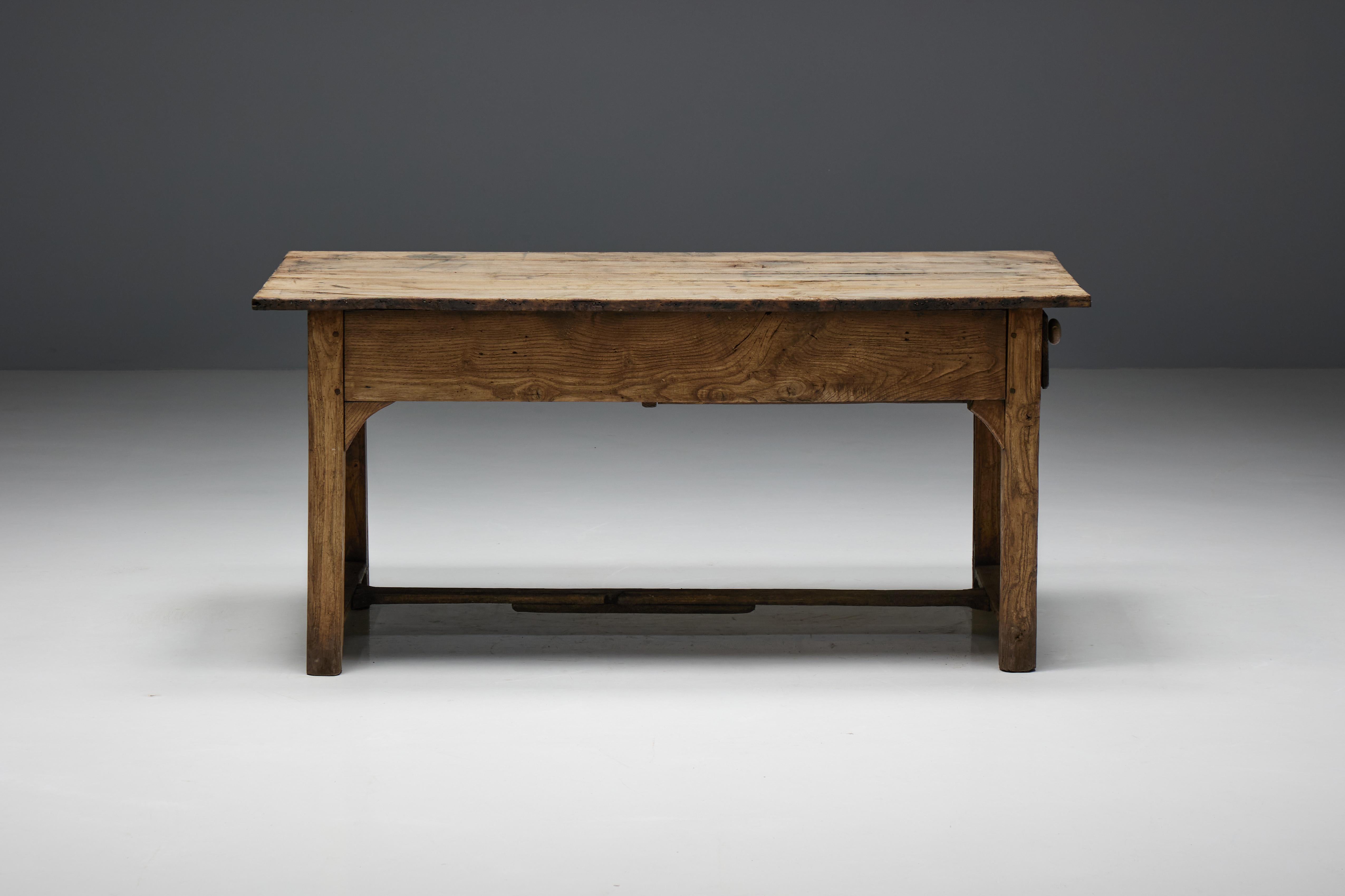 Originaire de la France du XIXe siècle, cette table de ferme présente une patine naturelle attachante qui enrichit son charme rustique. La présence d'un tiroir ajoute à sa fonctionnalité et offre un espace de rangement généreux pour les objets de