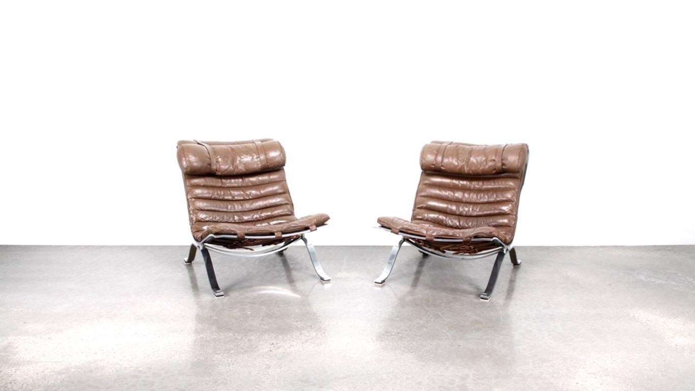 A great set of two Ari chairs in patinated brown leather.
by Arne Norell for Norell Mobel. 

Denmark, 1970s. 

These 1970s editions are in great condition, a hard to find pair.

Measures: 75 cm H x 65 cm W x 91 cm D.
 