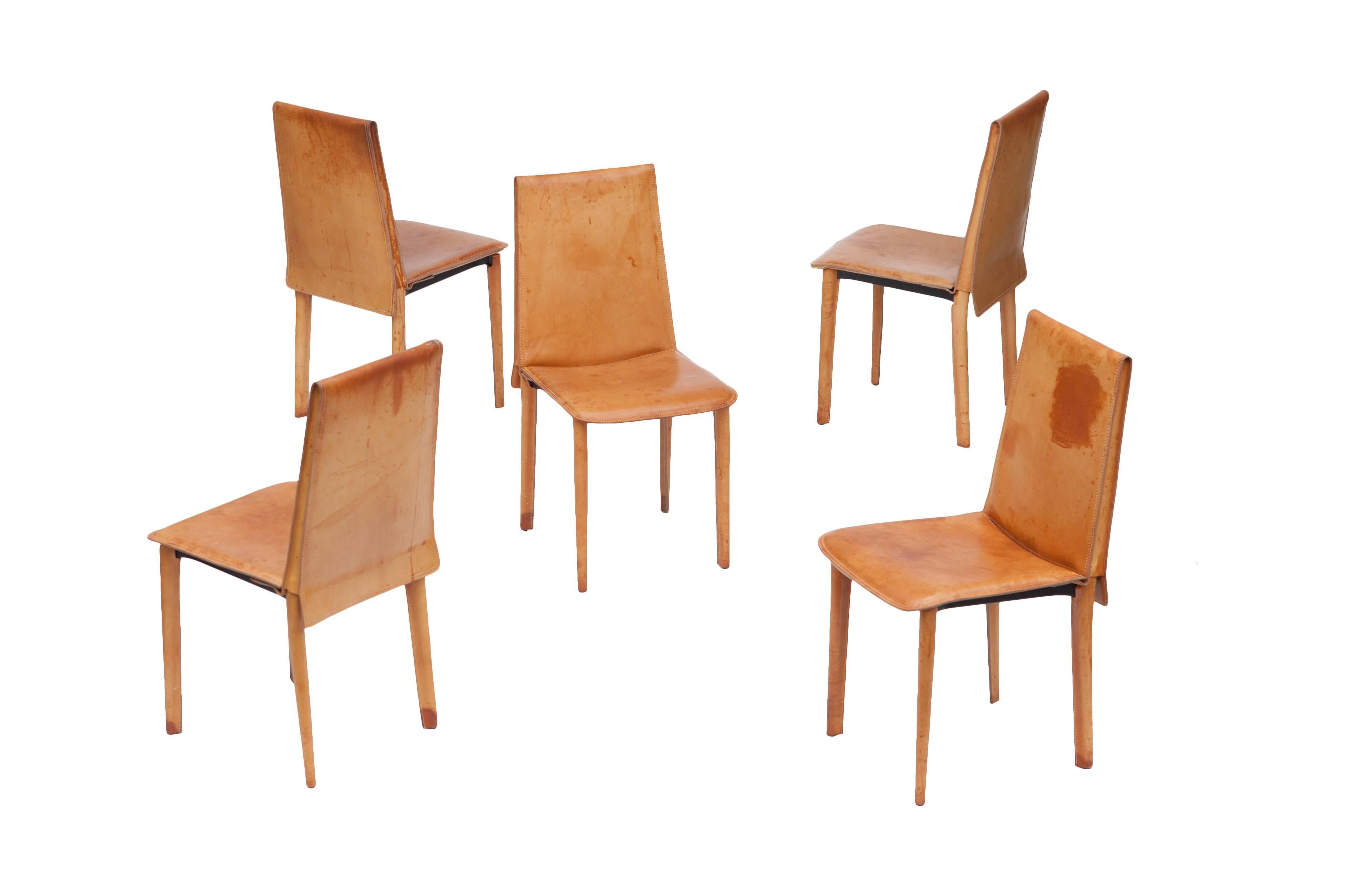 Stunning set of natural leather dining chairs which have Gotten an amazing cognac colored patina with age. Black metal frame fully covered with double stitched leather upholstery.

In the manner of Mario Bellini cab chairs and Matteo