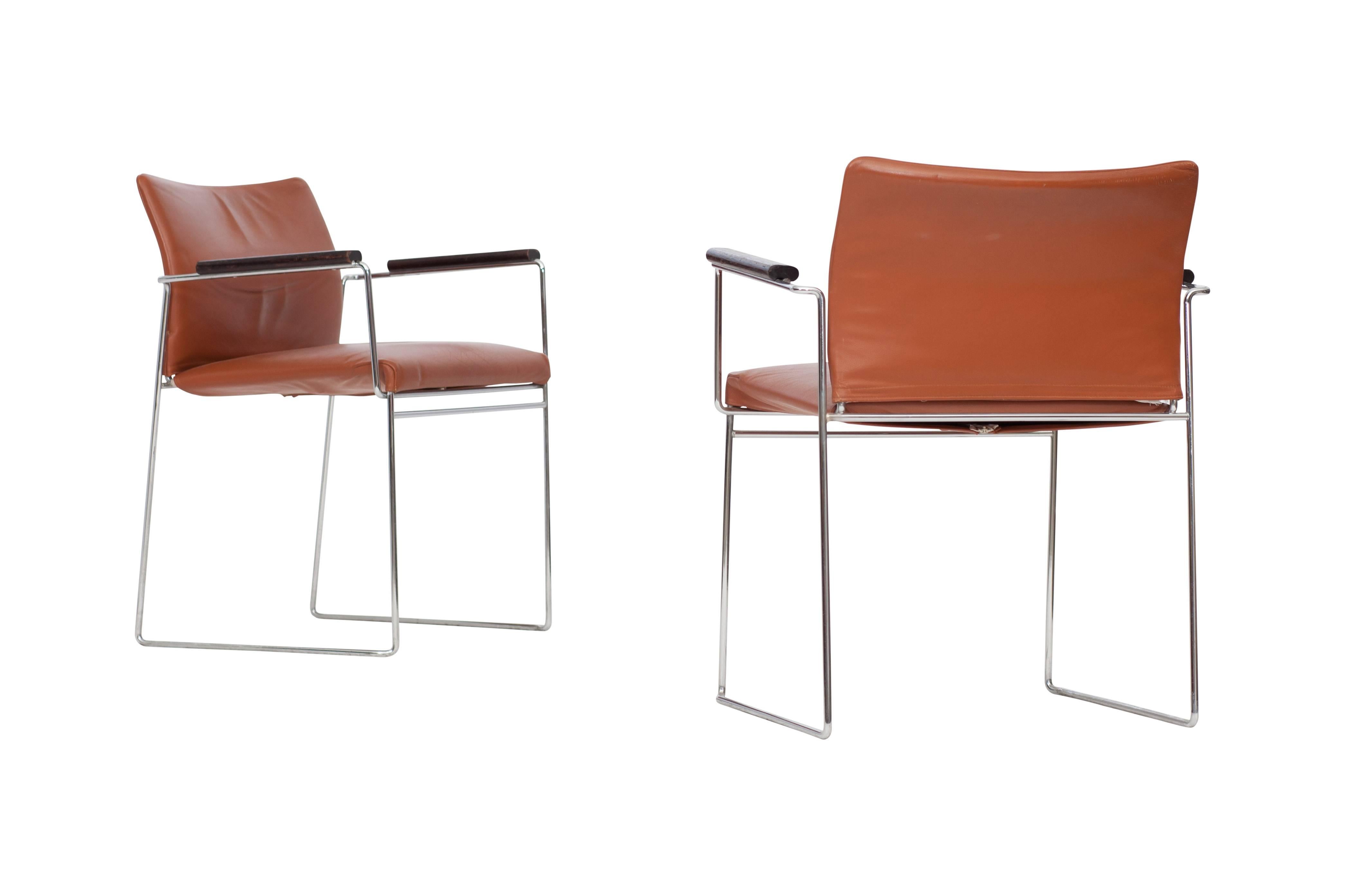 Set of four dining chairs, armchairs 

Reddish brown leather seating, chromed steel tubular frame and mahogany armrests.
Model Jano by Kazuhide Takahama for Cassina, 1969.

Measures: H 76 cm, SH 48 cm, W 60 cm, D 48 cm.
 