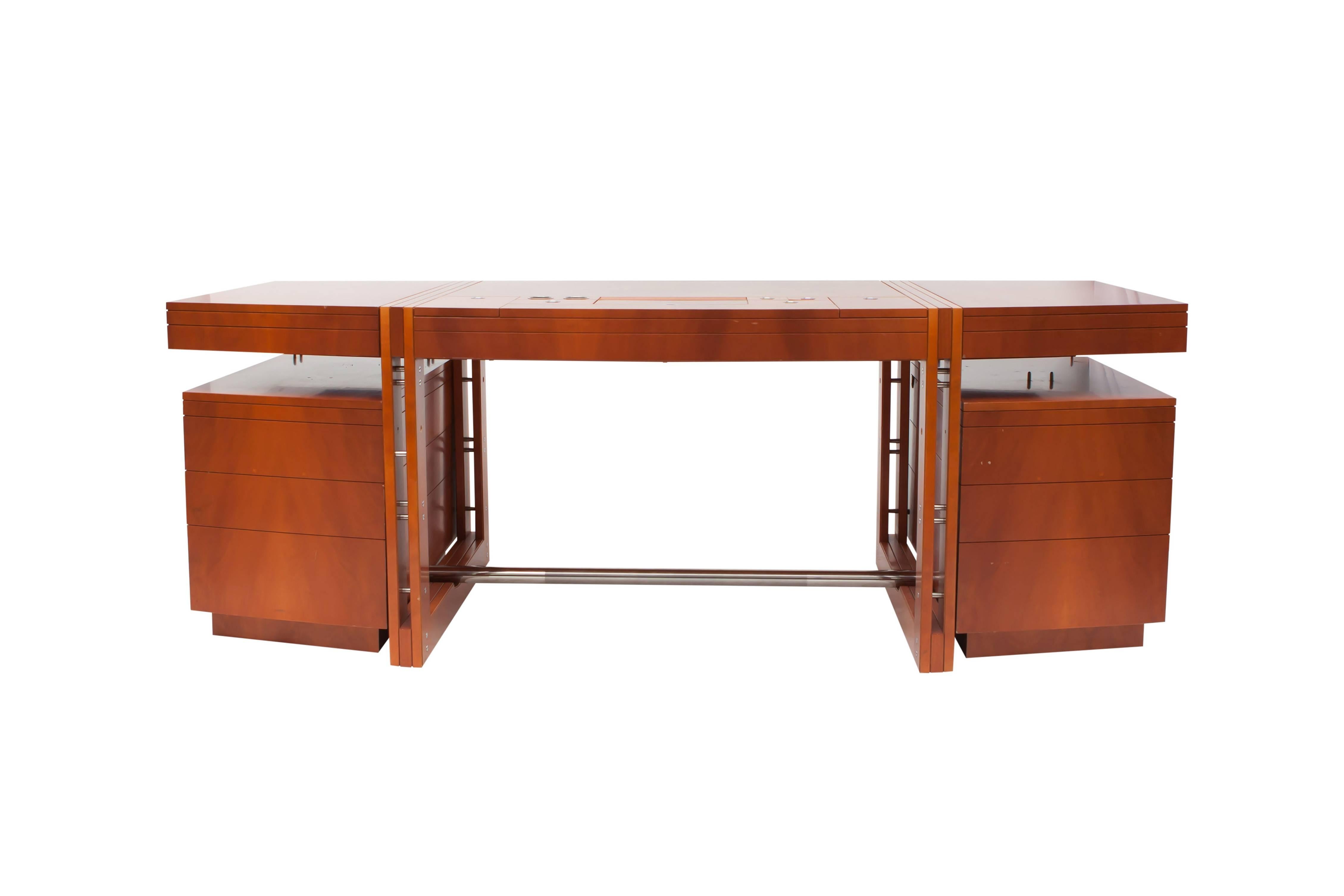 Post-modern High-end desk of the Tresserra collection.
It’s one of the most emblematic pieces of the collection, designed in 1988. 

This is an original model of the target desk.
Measures: L 210 cm x D 85 cm x H 74 cm.

Dark walnut wood. Tip-up