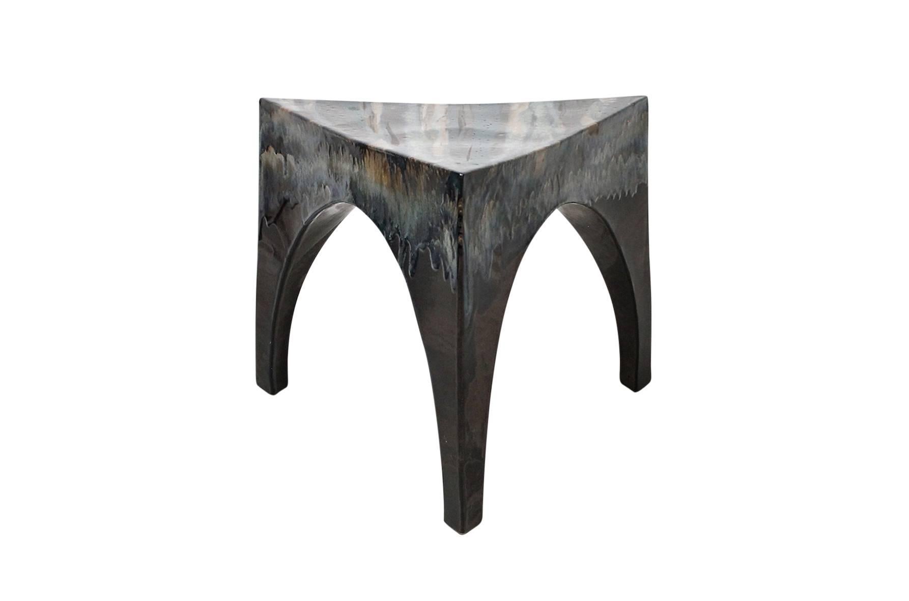 Triangular three-legged studio pottery table or stool. Suitable for indoor and outdoor use. Expertly crafted piece with artistic drip glazing over a matte black form.
