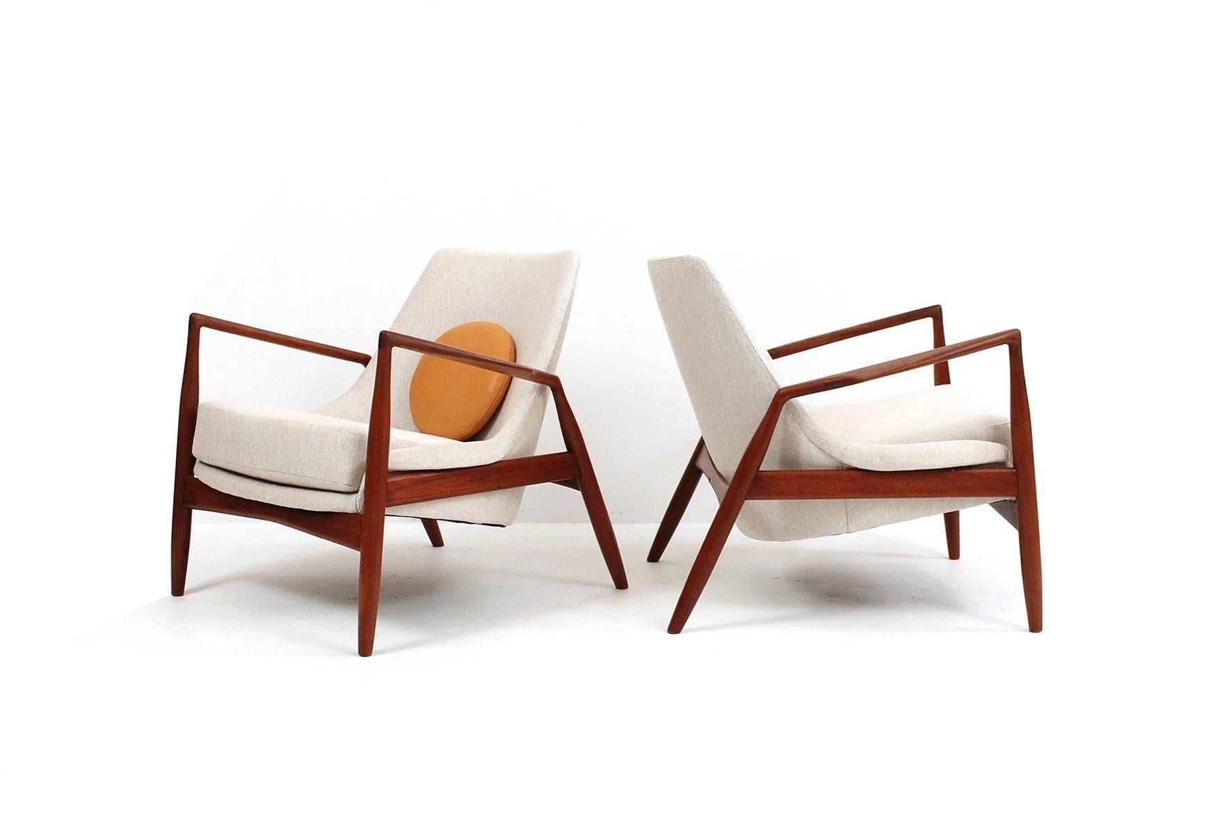 Sculptural pair of teak “Seal” lounge chair designed by Ib Kofod Larsen for Swedish firm OPE Mobler. Recently re-upholstered. Accented with circular leather pillows. Outstanding lounge seating.