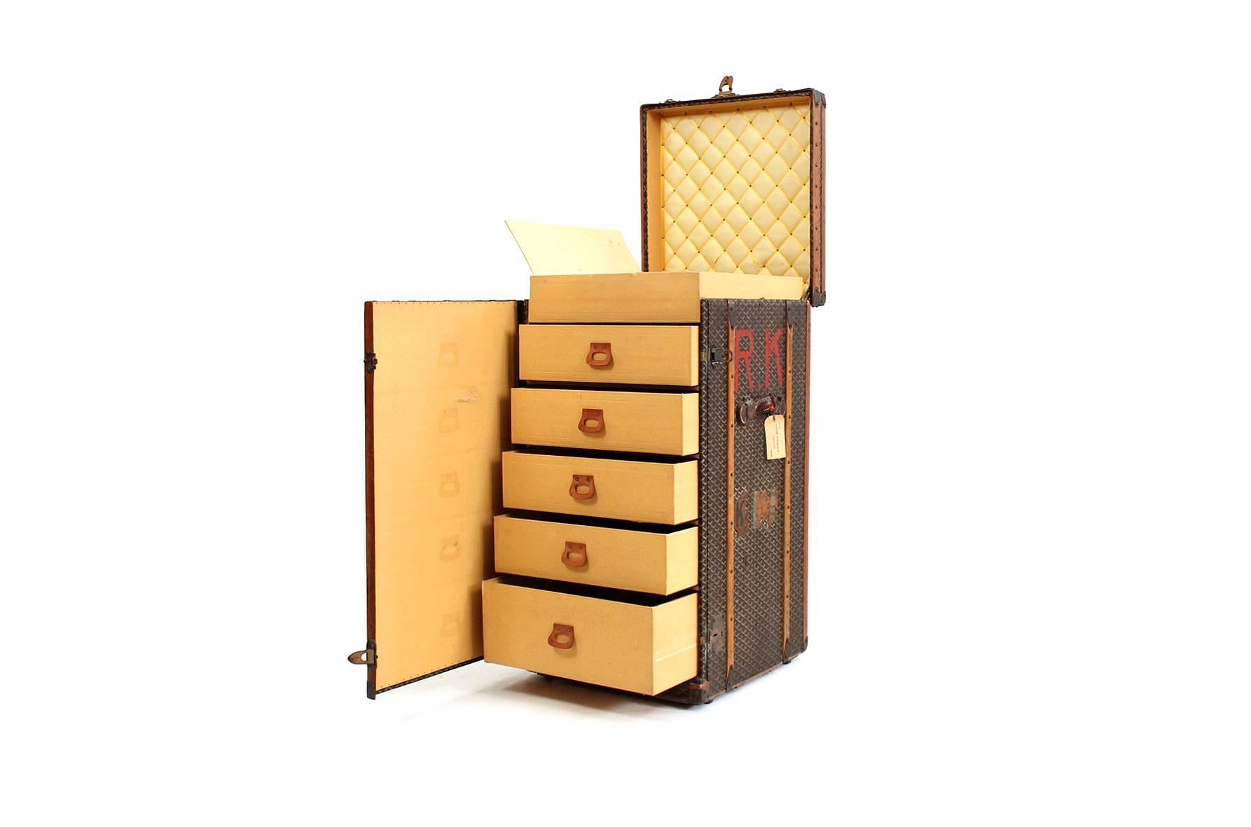 Seldom seen Goyard standing chest trunk covered in Classic chevron canvas, with brass hardware, leather and wood trim. The top of the trunk opens to reveal divided compartments. The front of the trunk opens to reveal 5 drawers with Goyard branded