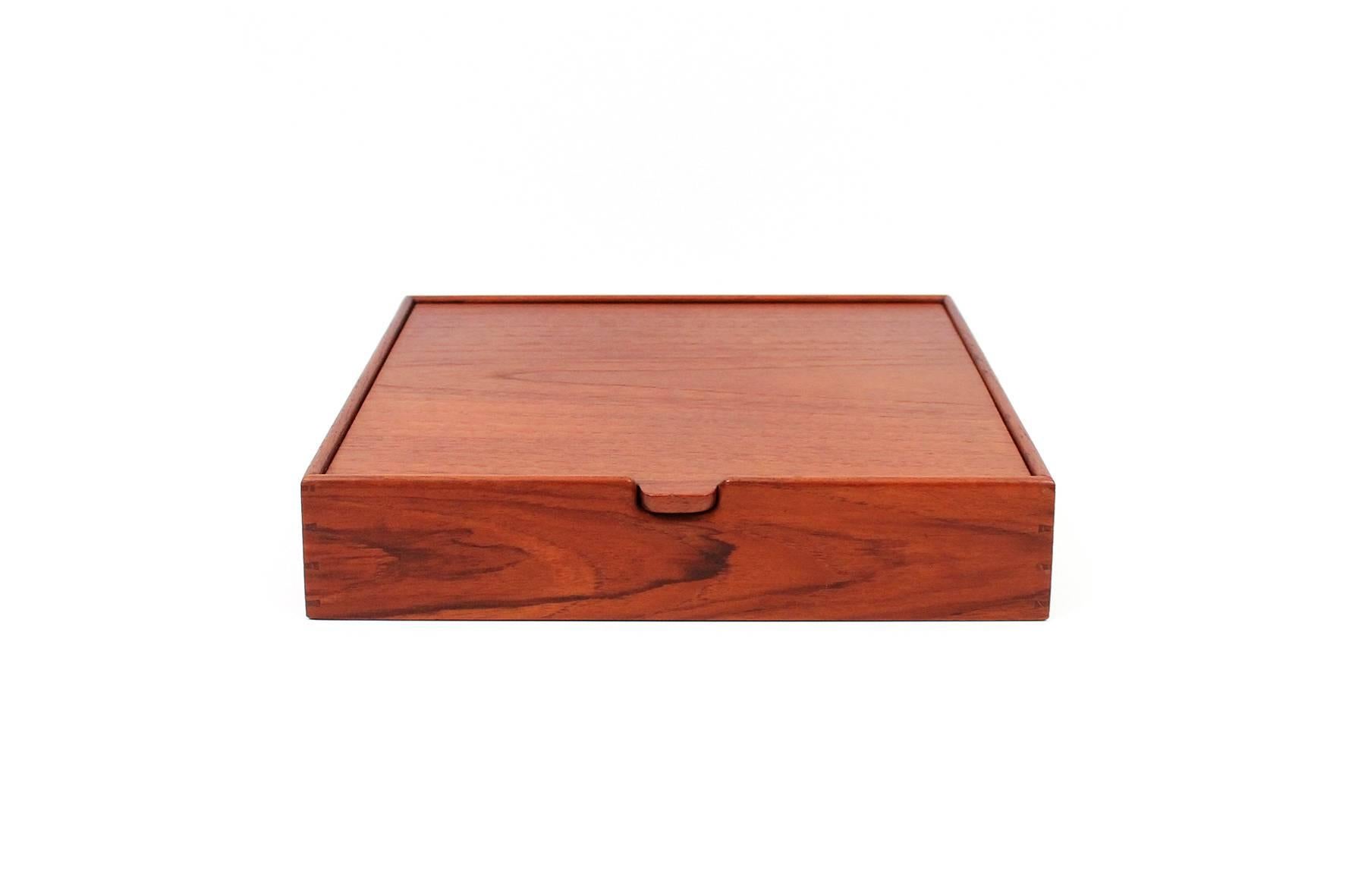 Teak jewelry box designed by Ejner Larsen and A. Bender Madsen.  Executed by Danish cabinetmaker Willy Beck.  Box features a flip top lid with mirror and an interior with two adjustable dividers. Superb construction and detailing.  Signed with