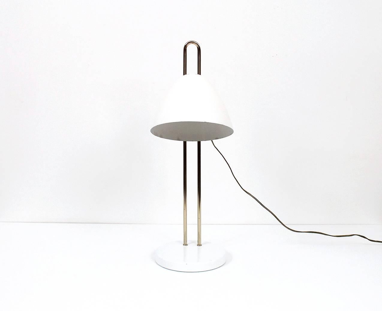 Seldom seem table or desk lamp by Lightolier. Lamp features a pivoting white enameled shade and brass components. The shade can also be adjusted for height up or down the vertical brass fork. Ingenious design and build reminiscent of Italian desk