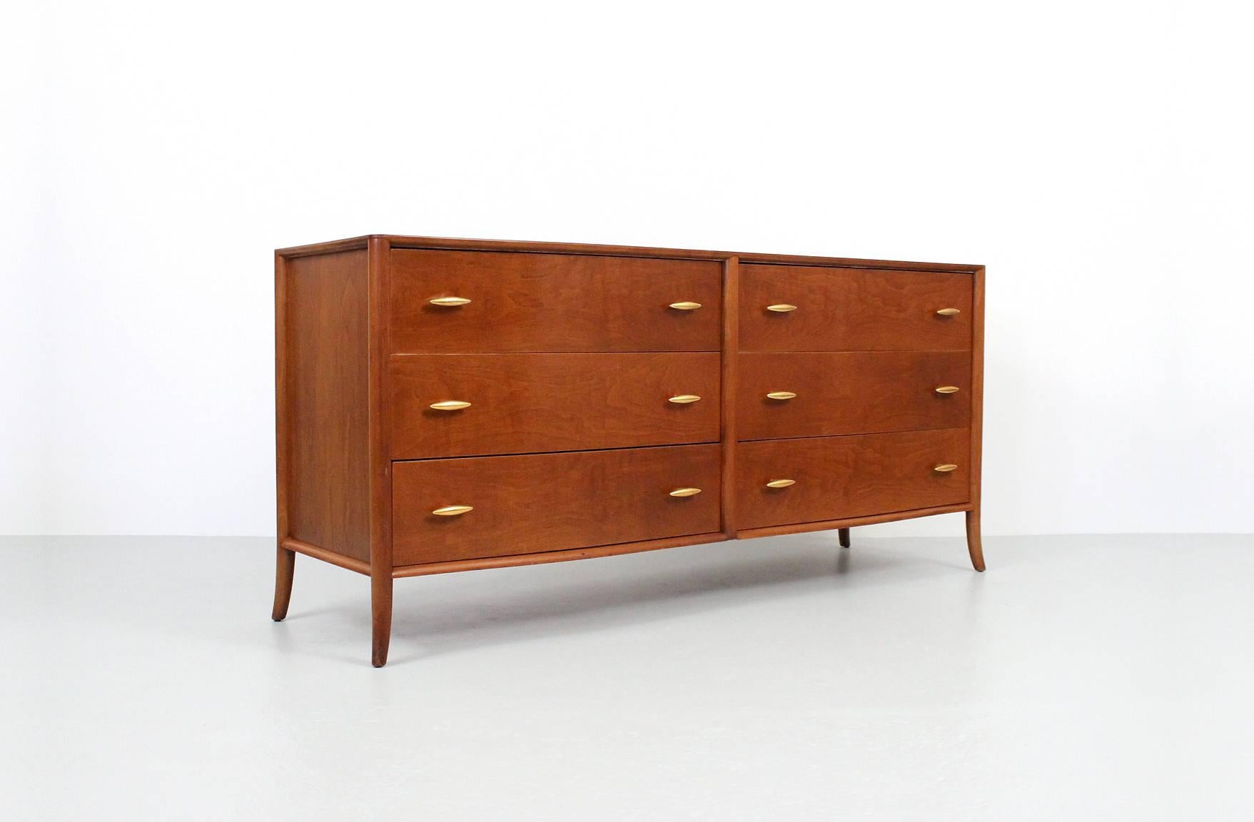 Curved front dresser designed by T.H. Robsjohn-Gibbings for Widdicomb. This well proportioned chest features gold-plated porcelain hardware, bookmatched walnut drawer fronts, and saber legs. This piece has all original drawer dividers and interior