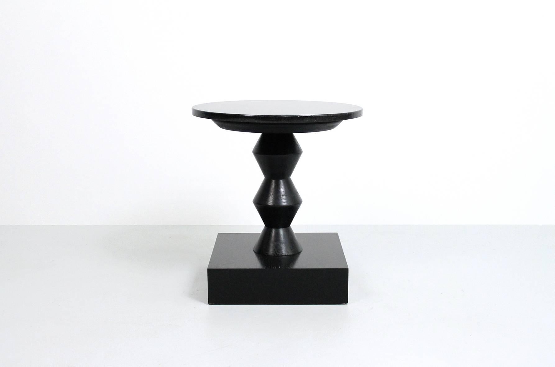 Rare Peter Shire Post Modern side/lamp table with black cerused wooden base and circular granite top. This example comes from a commission of custom Shire designs. The artist has confirmed the authenticity of this piece.

____

We're offering our