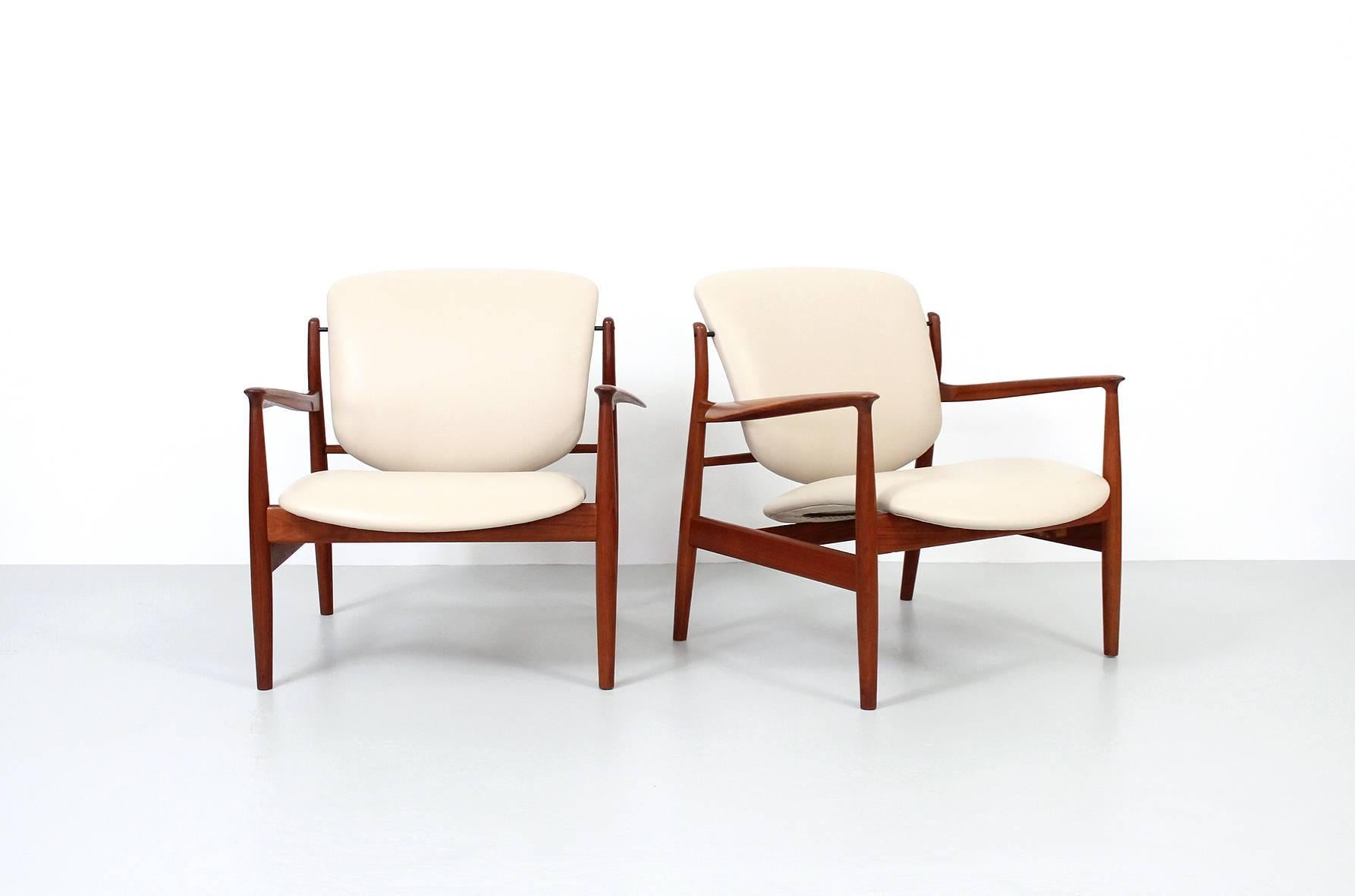 Pair of sculptural teak and leather lounge chairs designed by Finn Juhl for France & Daverkosen. These are model FD 136. Recently reupholstered in beige leather.