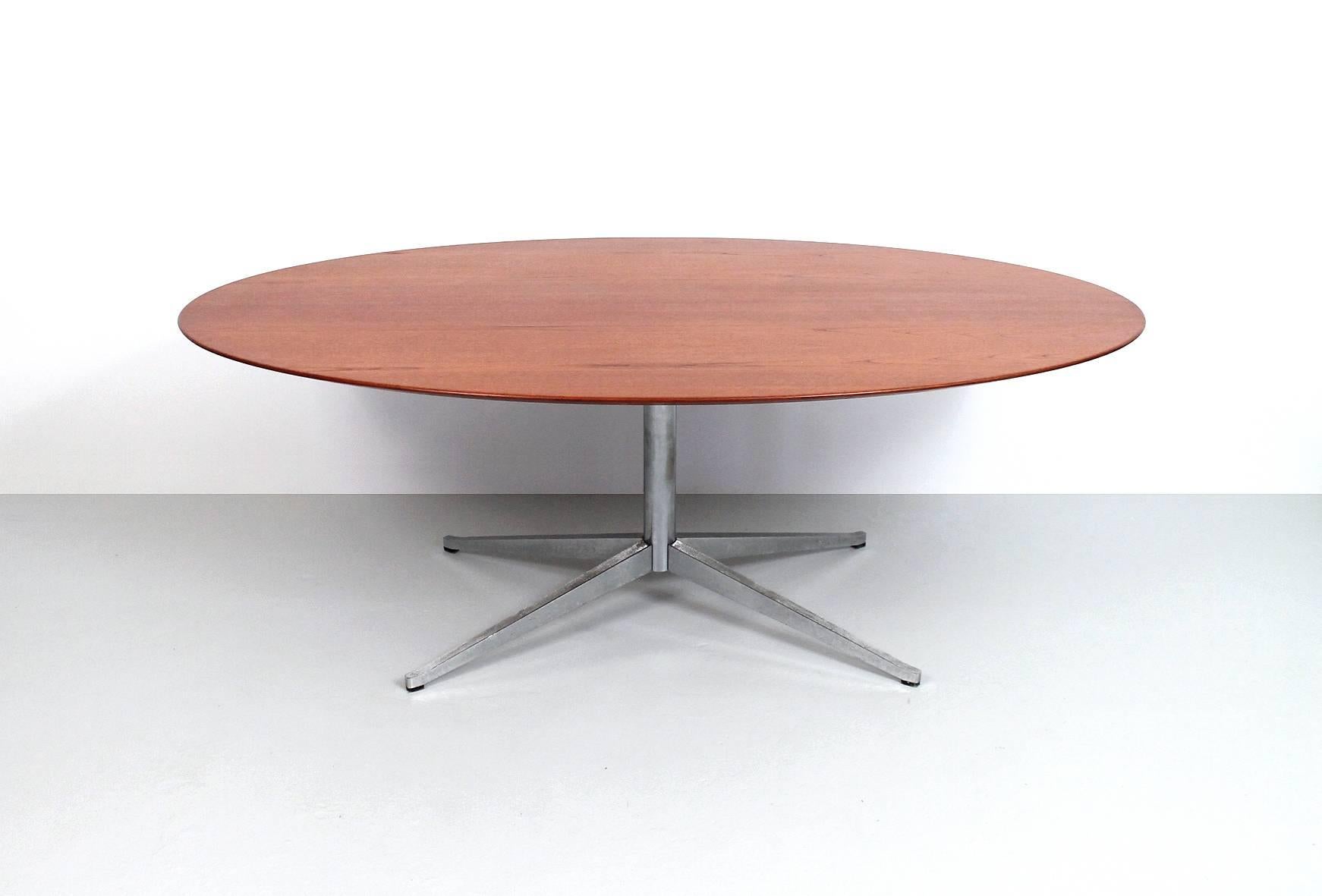 Florence Knoll designed oval dining or conference table in teak. Wonderfully grained teak top sits atop a chrome-plated steel base. Classic form by the noted American designer.