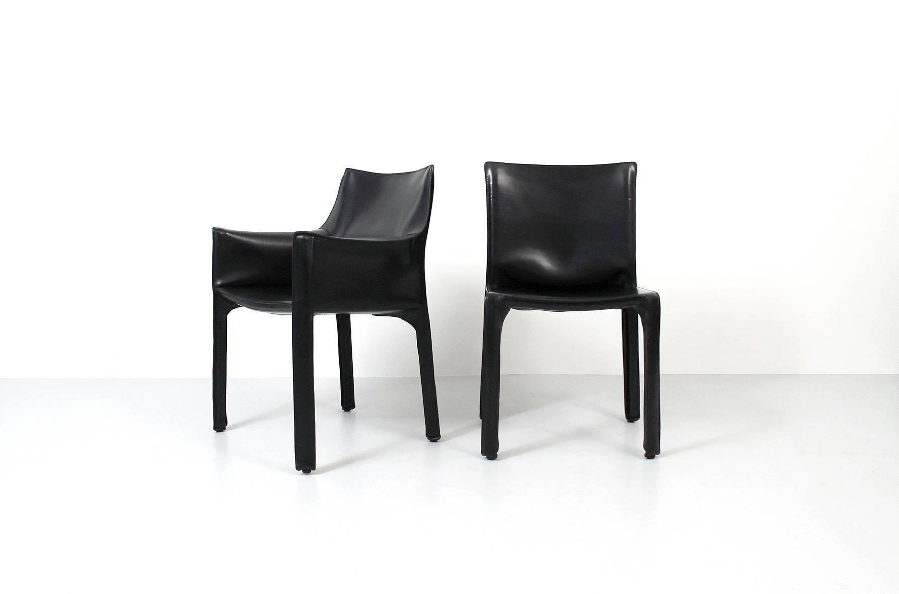 Eight CAB dining chairs by Italian designer Mario Bellini for Cassina. This set comprised of six sides and two arms. These vintage examples of the popular chairs are in black belting leather. Marked with impressed Cassina brand and Atelier