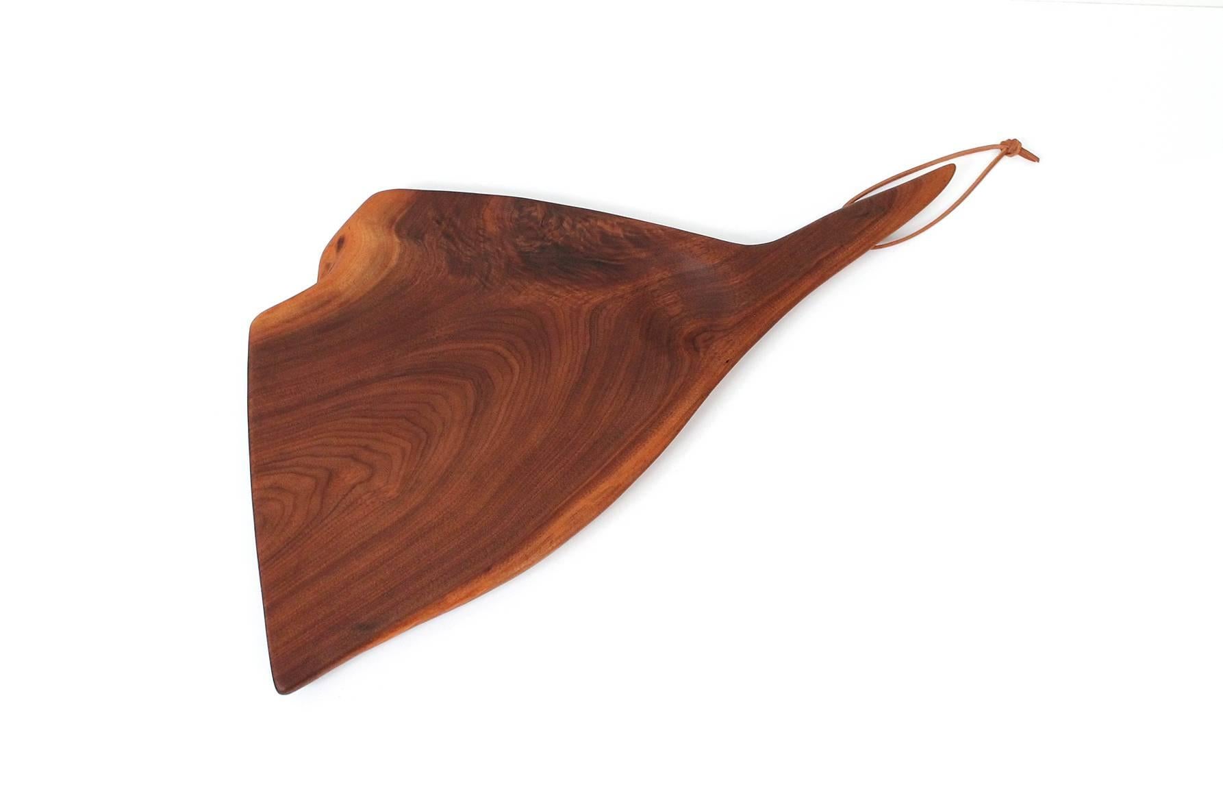 Rare cutting board in walnut by American studio furniture maker Dirk Rosse. Sculptural and considered form inspired by the cutting boards of Wharton Esherick. Rosse was born in the US, raised in Holland, and settled in Millbrook, NY where he crafted
