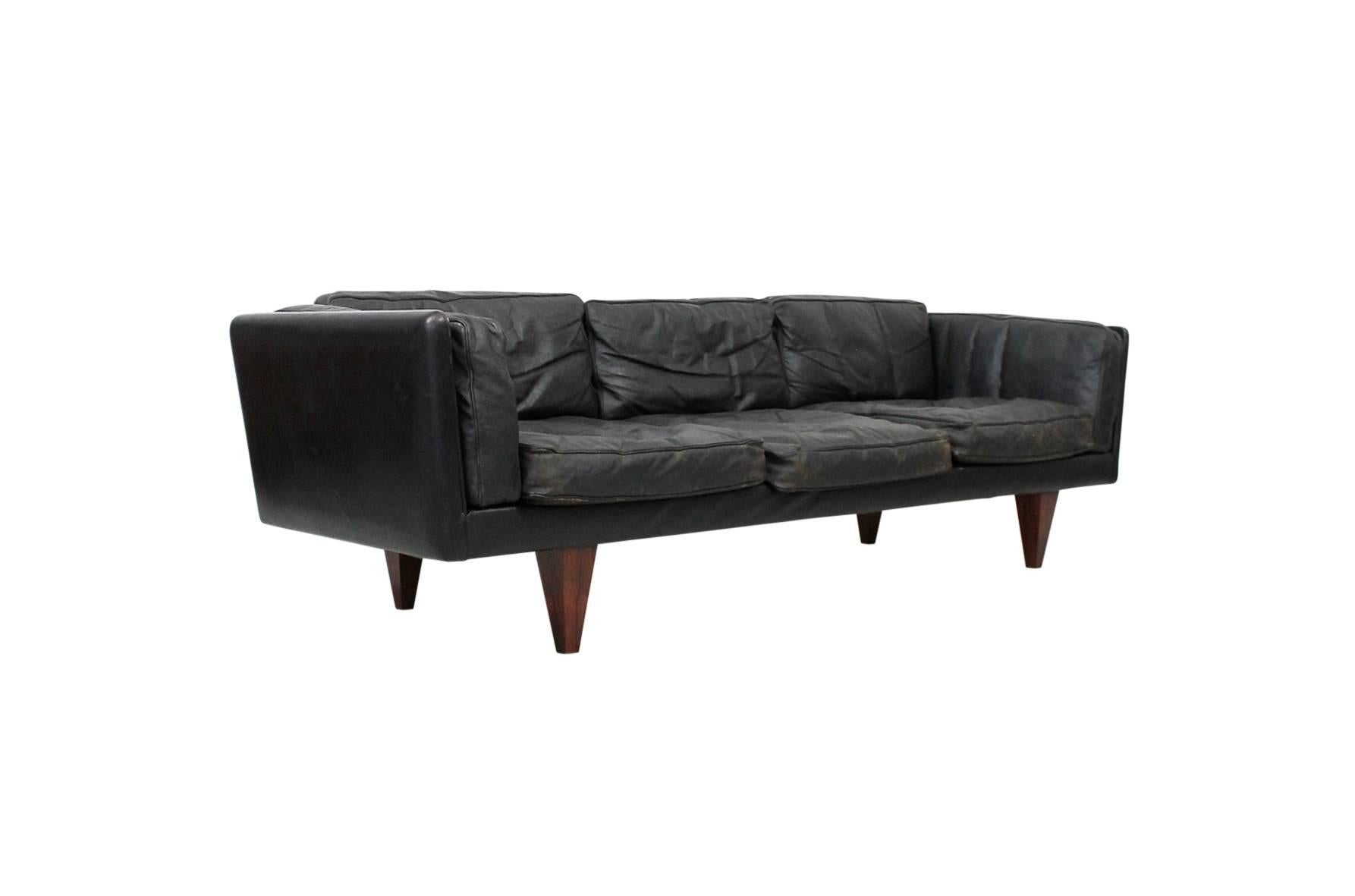 Model V11 sofa in leather and rosewood designed by Illum Wilkkelso for Holger Christiansen. This sofa features original black leather and down cushions with substantial pyramidal rosewood legs.