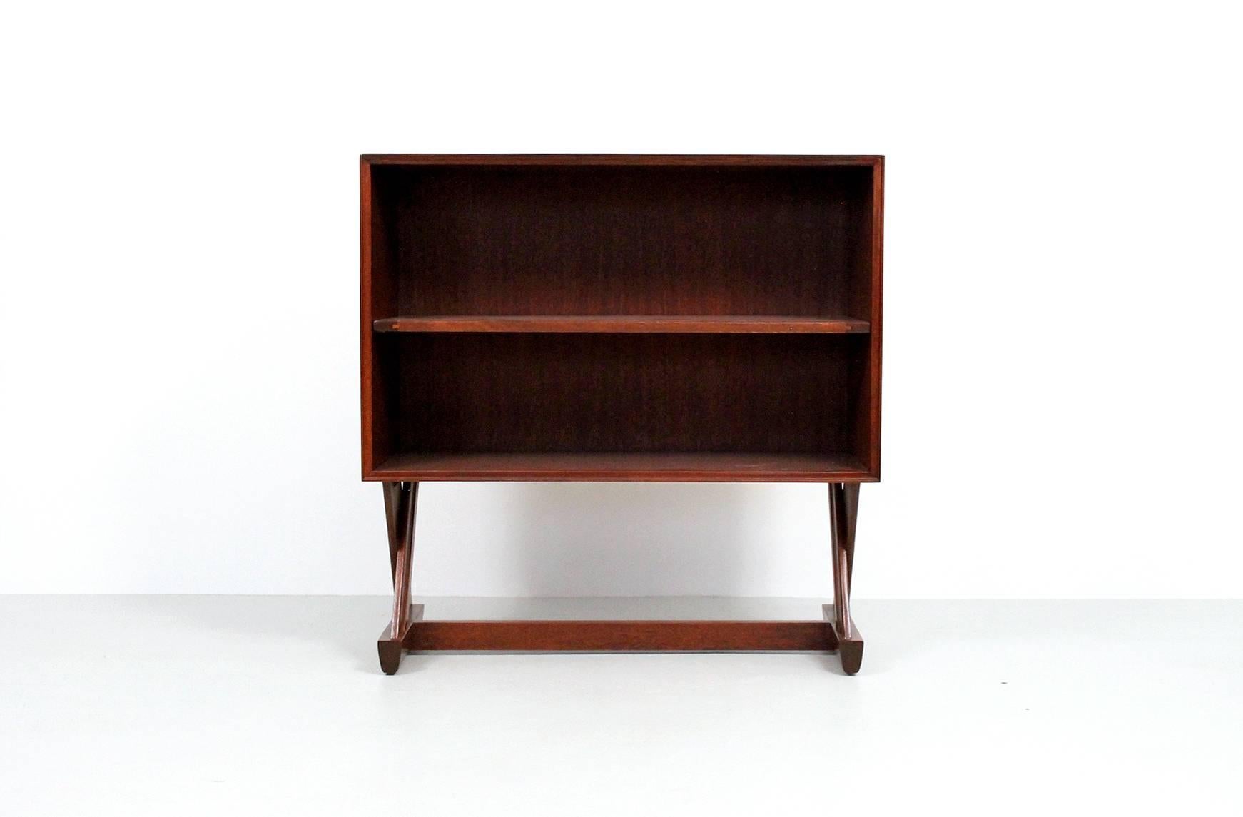 Matched pair of bookcases designed by Paul Laszlo for Brown Saltman. Bookcases executed in mahogany and feature opposing X-bases and a single adjustable shelf. Marked on reverse side. Placed side by side they create a large open console.