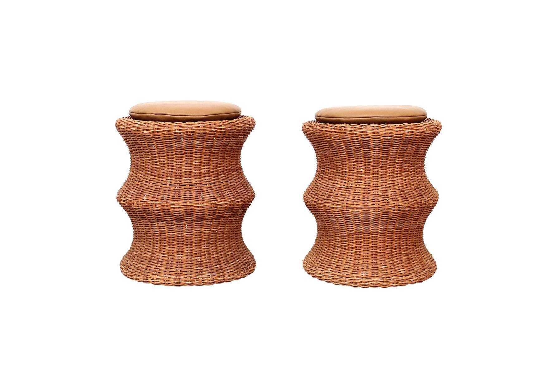 Early matched pair of "Juttu" stools by Eero Aarnio. Can be used as footstools or side tables. Original wicker has a pleasant golden patina. Made by Sokeva in Finland, circa 1960s. One example retains original decal "DESIGN EERO