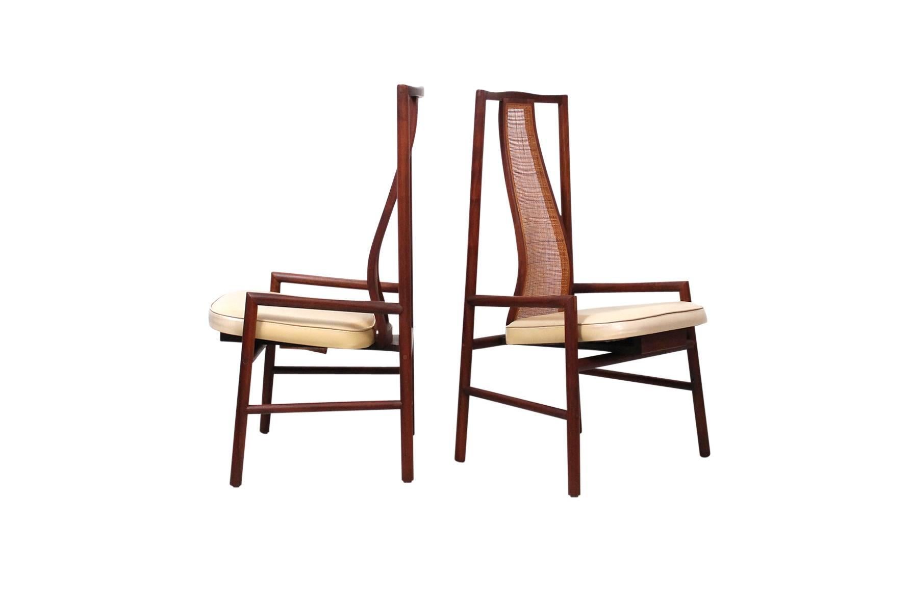 Pair of walnut and cane chairs designed by John Kapel for Glenn of California. This seldom seen design by Kapel features a sculptural caned backrest and artful joinery. One example retains original paper label.