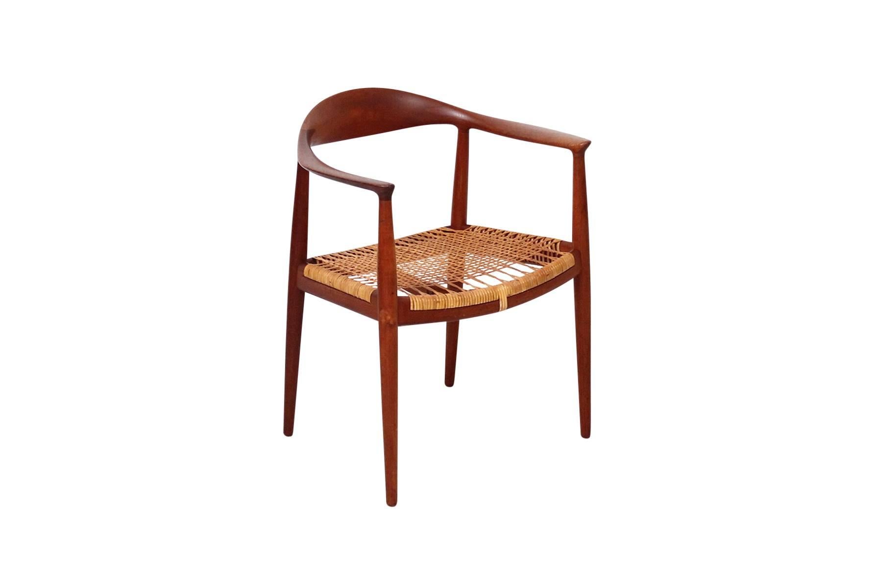 Single teak and cane Classic "The Chair" or "Round" chair by Hans Wegner for Danish cabinetmaker Johannes Hansen. Caned seat and sculptural teak backrest.
 
