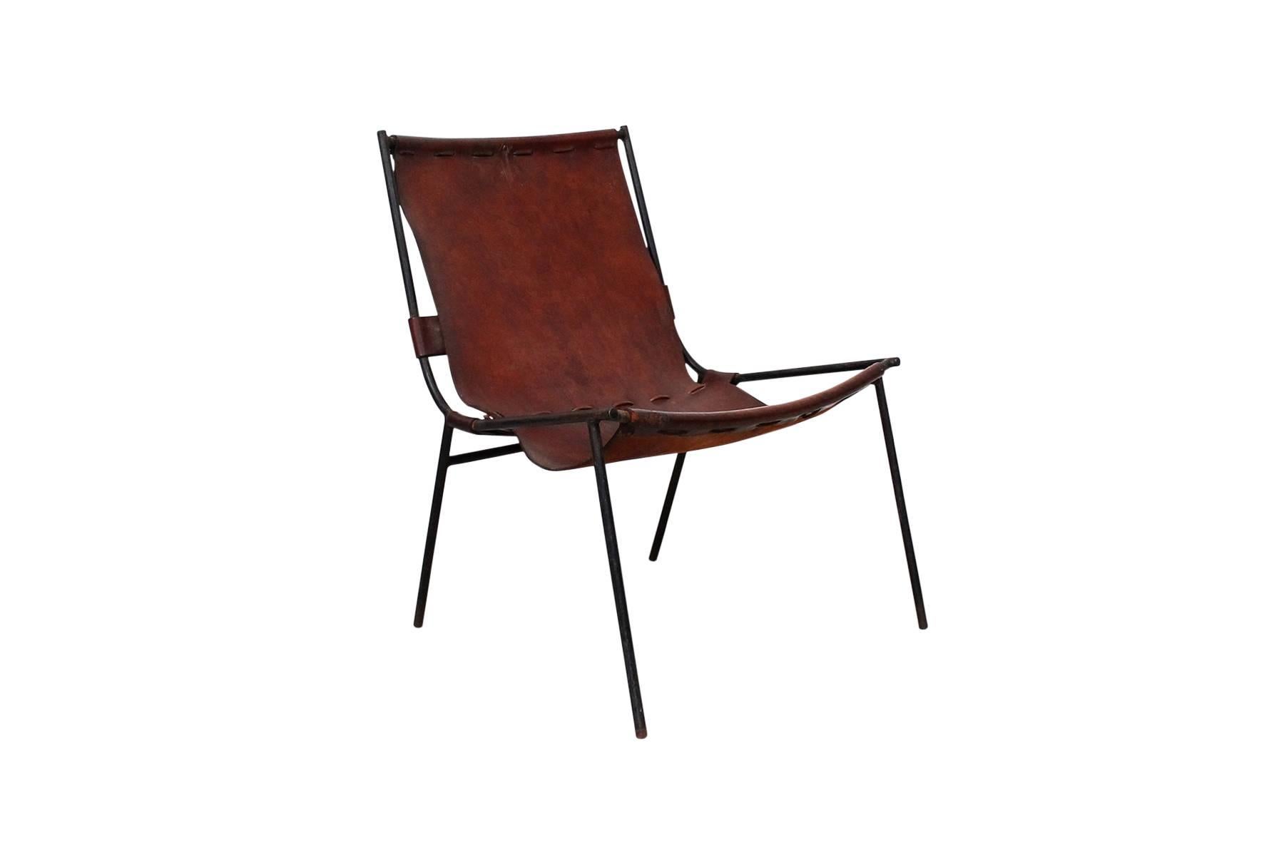 Rare iron and leather sling chair by noted New Hampshire craftsman Gordon Keeler. Keeler widely exhibited his turned wood bowls in New England for many decades. This chair is an early experiment in leather work. Leather sling branded with the Keeler