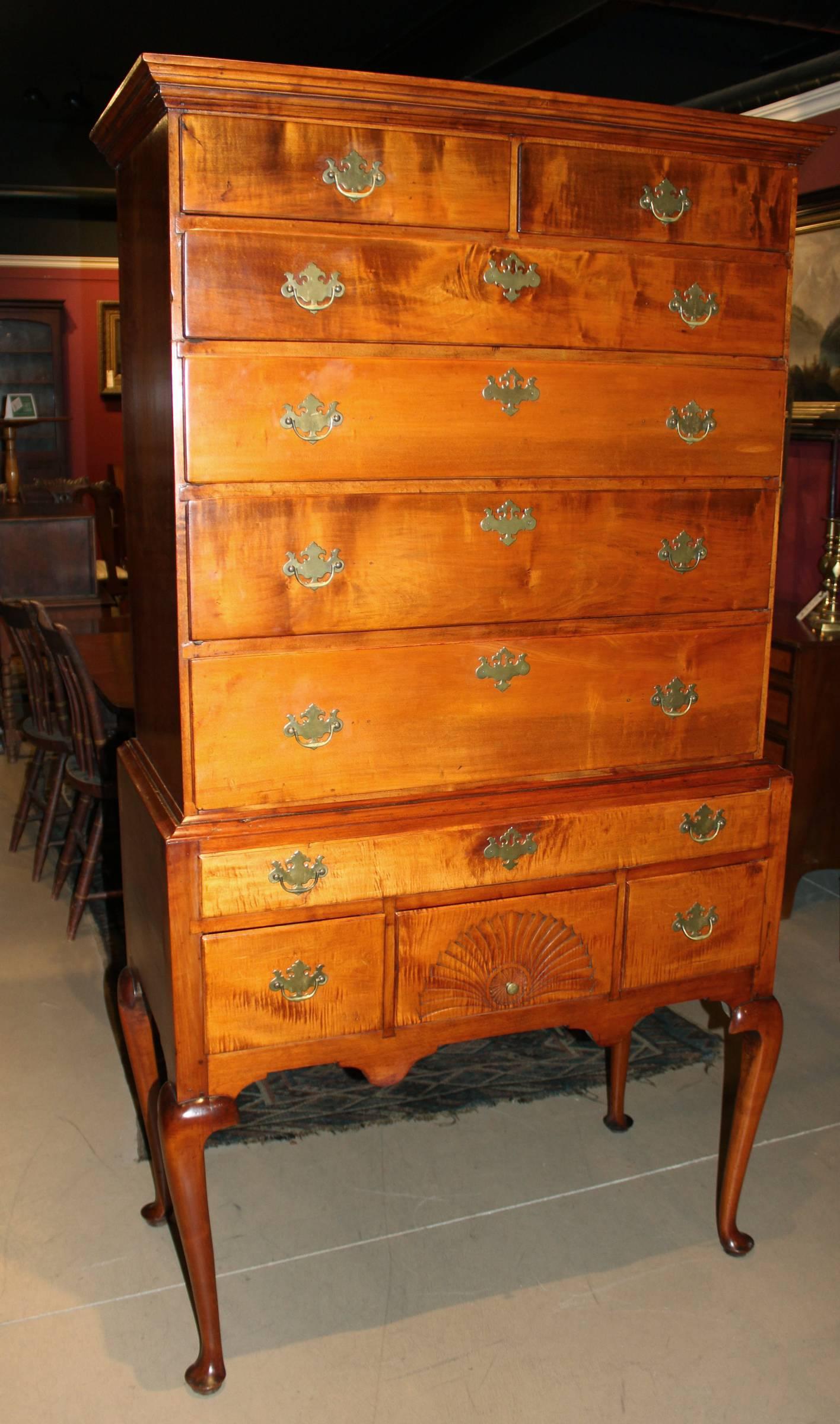 A fine curly maple highboy or high chest, attributed to Moses Hazen of Weare, New Hampshire, with an upper case of two over four drawers, supported by a lower case with one long drawer over three short drawers, the center with a linen fan and