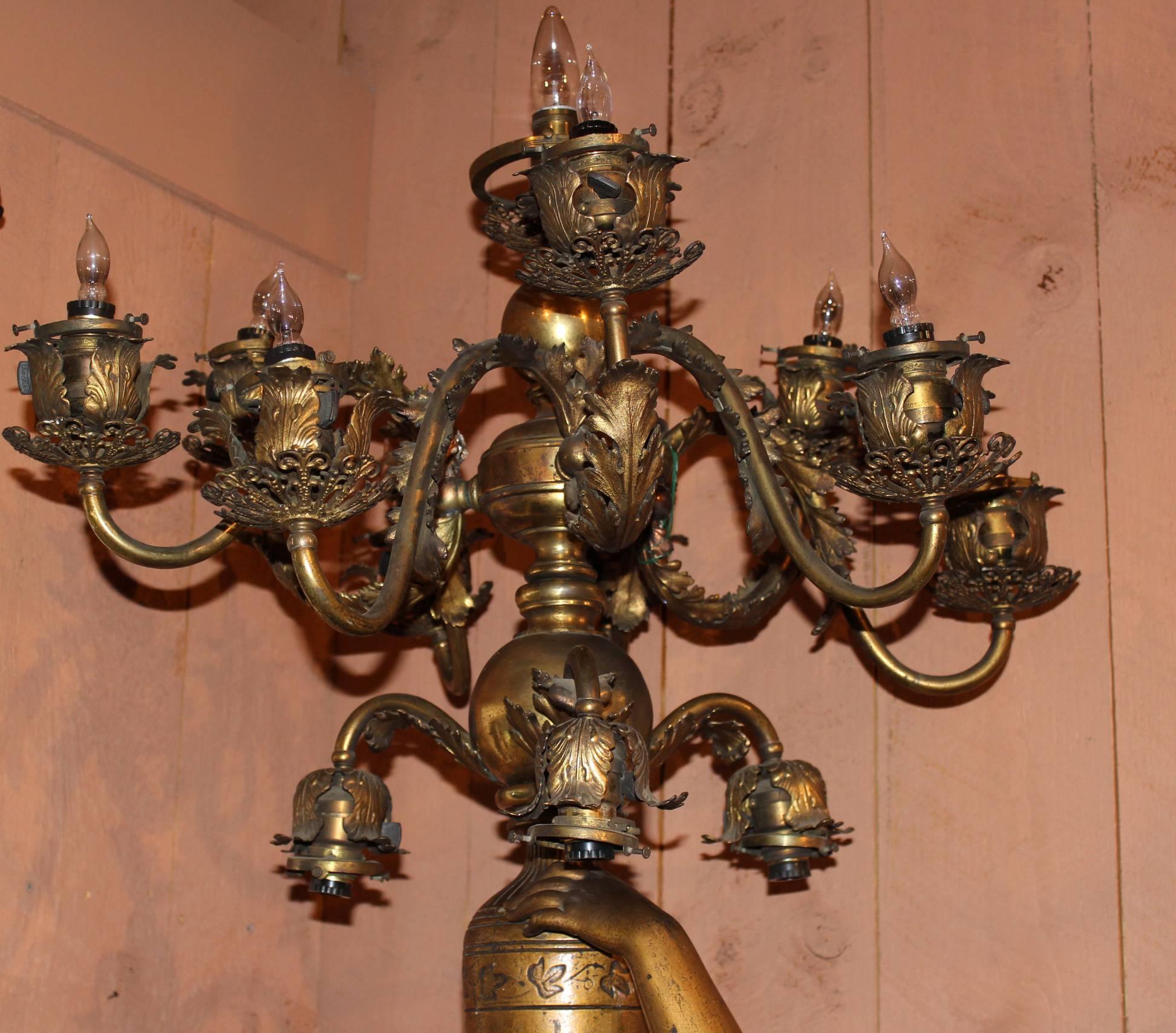 A magnificent French, Victorian patinated bronze figural floor candelabra in the form of a near lifesize robed maiden with an upstretched arm holding an urn and a thirteen branch candelabra as well as a garland of flowers. The candelabra itself has