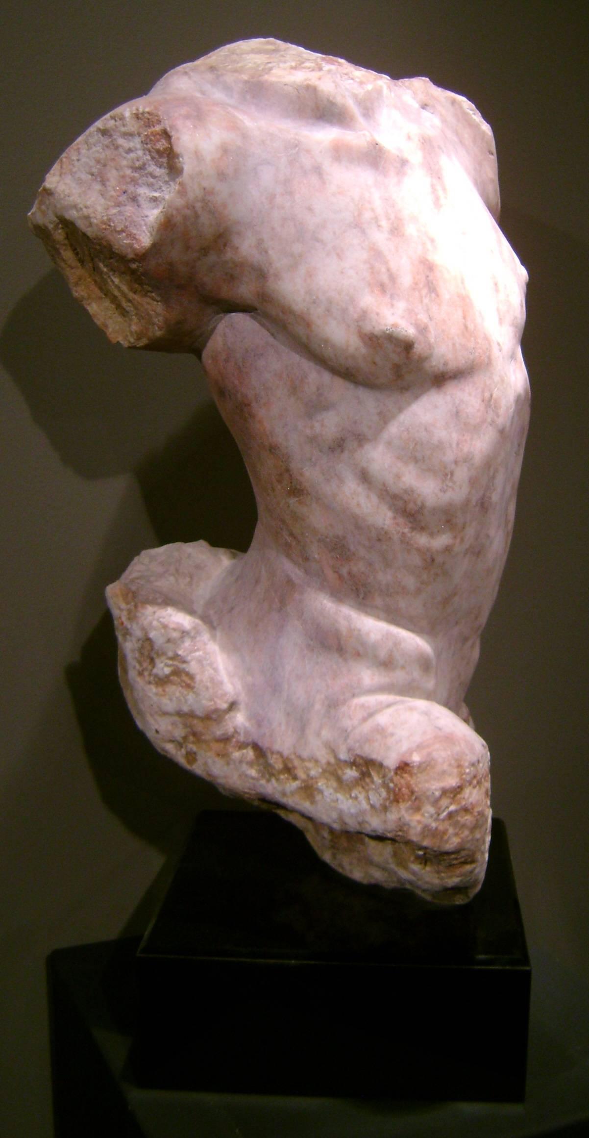 Classical stone sculpture of male torso carved by Martin Glick, a contemporary artist with studio in Pomona, New York.  This carved stone piece is mounted on a black plinth base.
